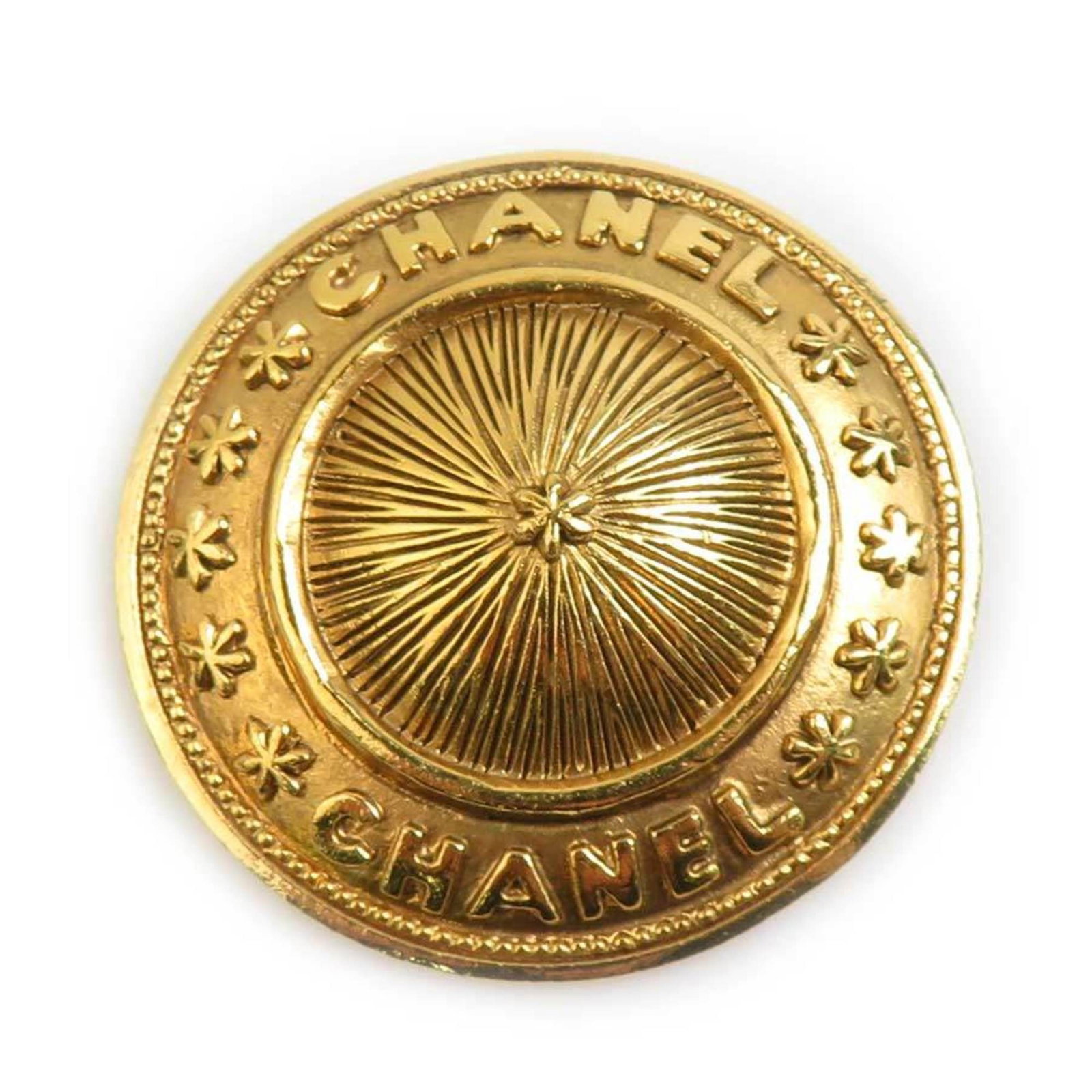Metal brooch by Chanel: Metal brooch by Chanel Gold metal brooch by Chanel, measuring 3.8cm x 3.8cm, bears visible traces of usage and minor scratches/dirt. The item's condition reflects its used state, with signs of wear