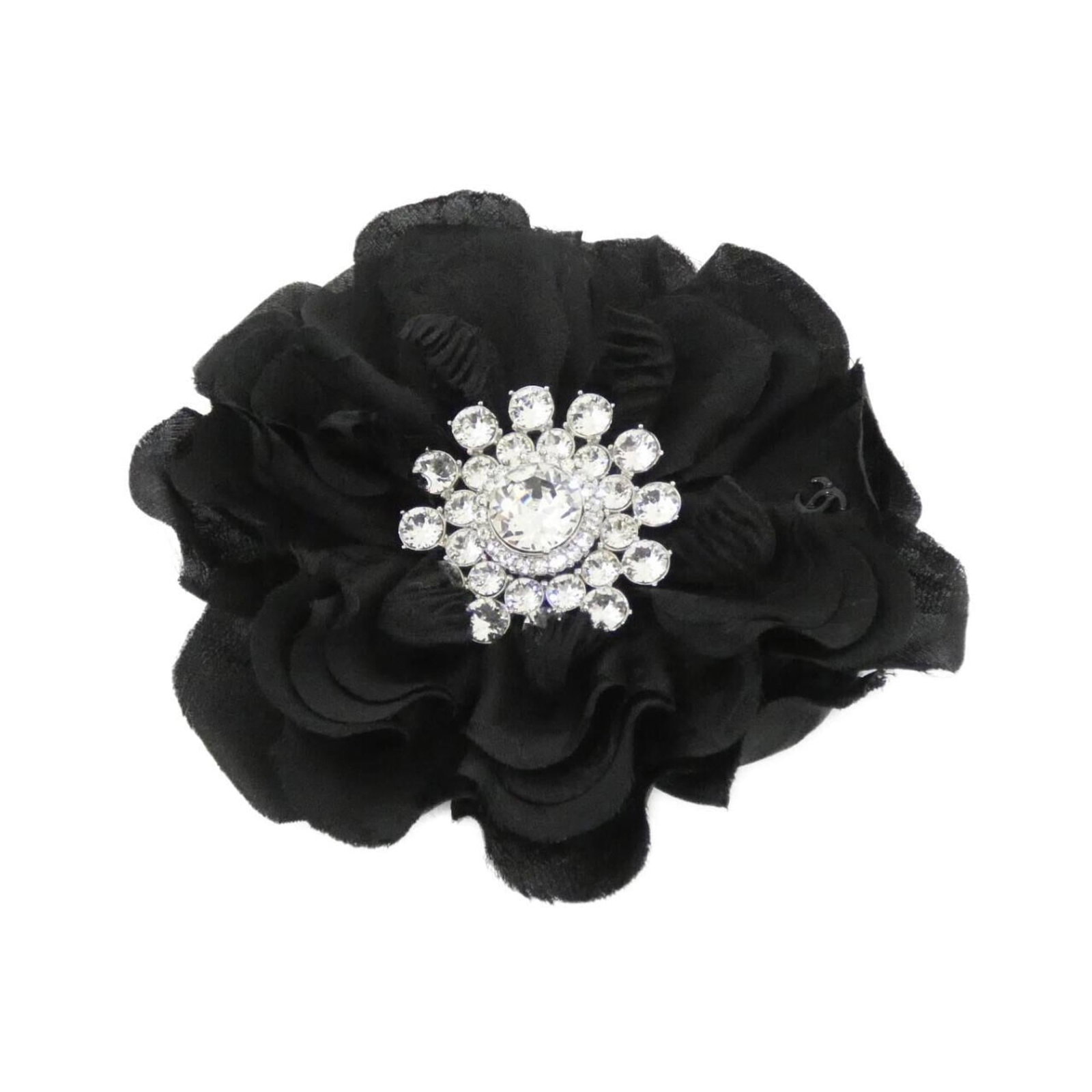 Corsage Silk by Chanel: Corsage Silk by Chanel Silk Corsage from iconic fashion house Chanel, featuring a striking black and silver design adorned with crystal accents. This used corsage measures 10cm x 10cm and boasts a few