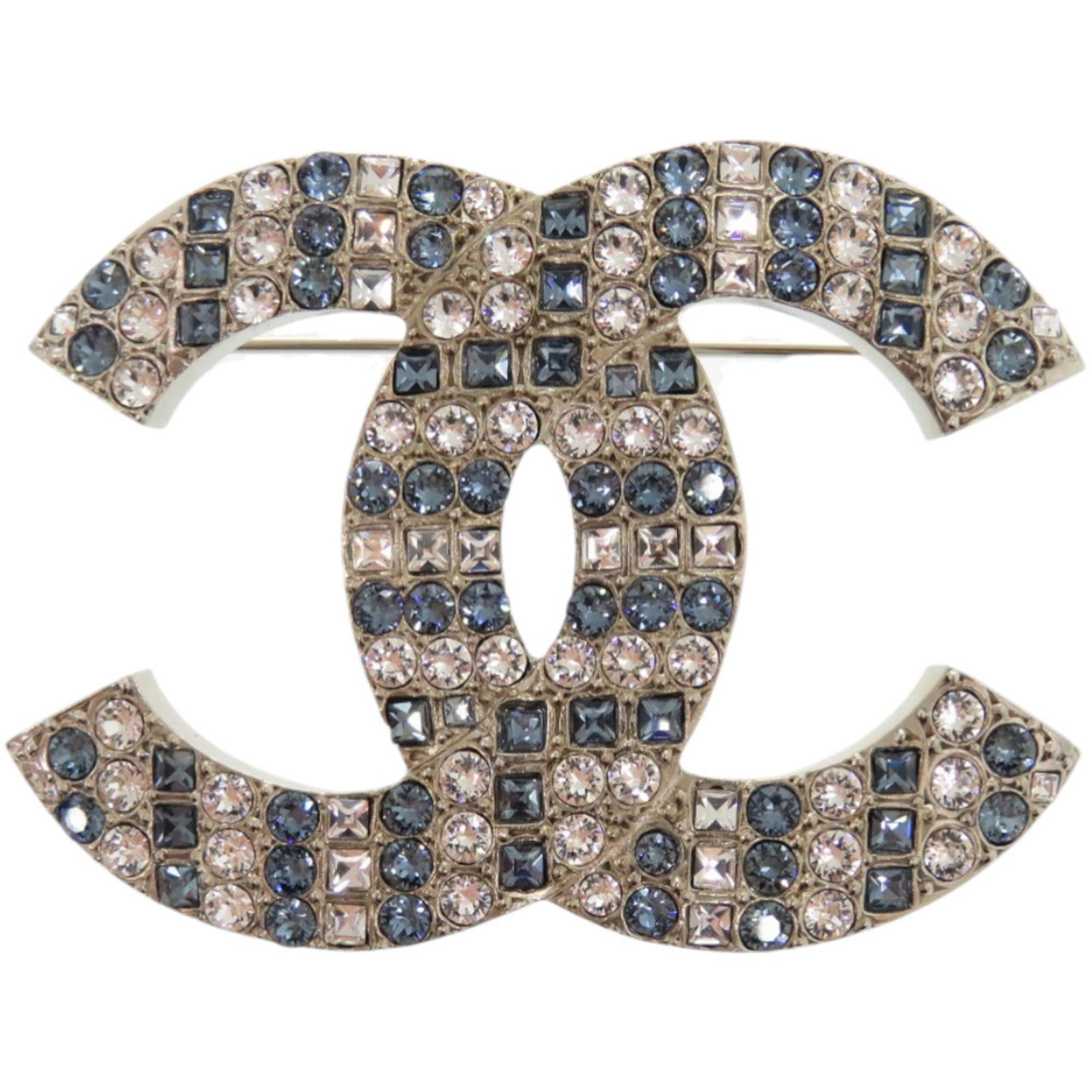 Metal brooch by Chanel: Metal brooch by Chanel The Chanel metal brooch boasts a striking blue, silver, and white design adorned with rhinestones. Measuring 3.9cm x 5.2cm, it features a few traces of usage, some scratches / d
