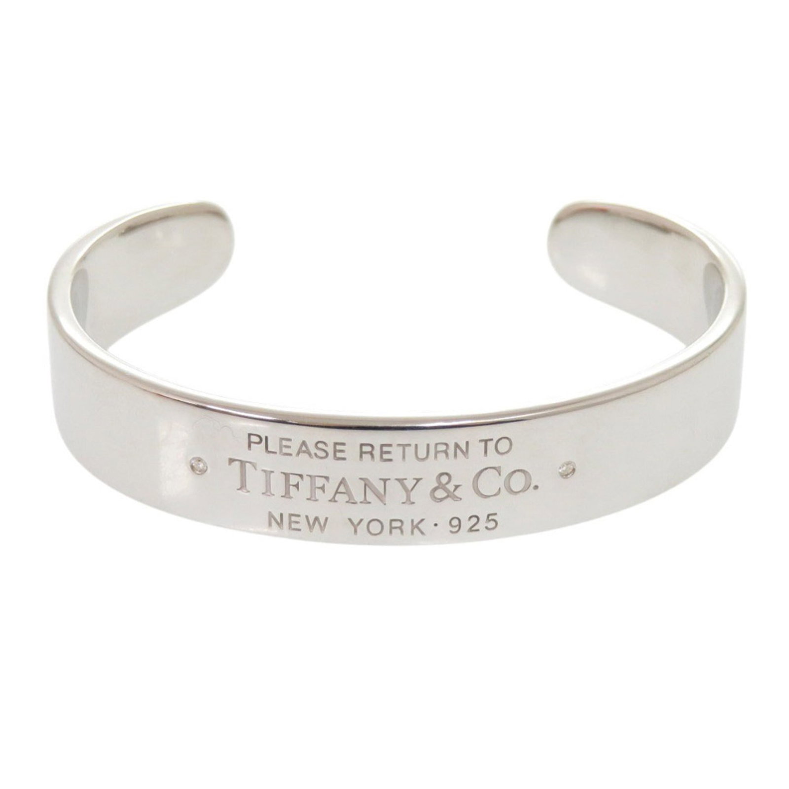 Silver Bangle Tiffany: Silver Bangle Tiffany Silver Bangle Tiffany, made from high-quality 925 silver, features a sleek and sophisticated design. The bangle's silver finish has some minor scratches and dirt, but overall rem