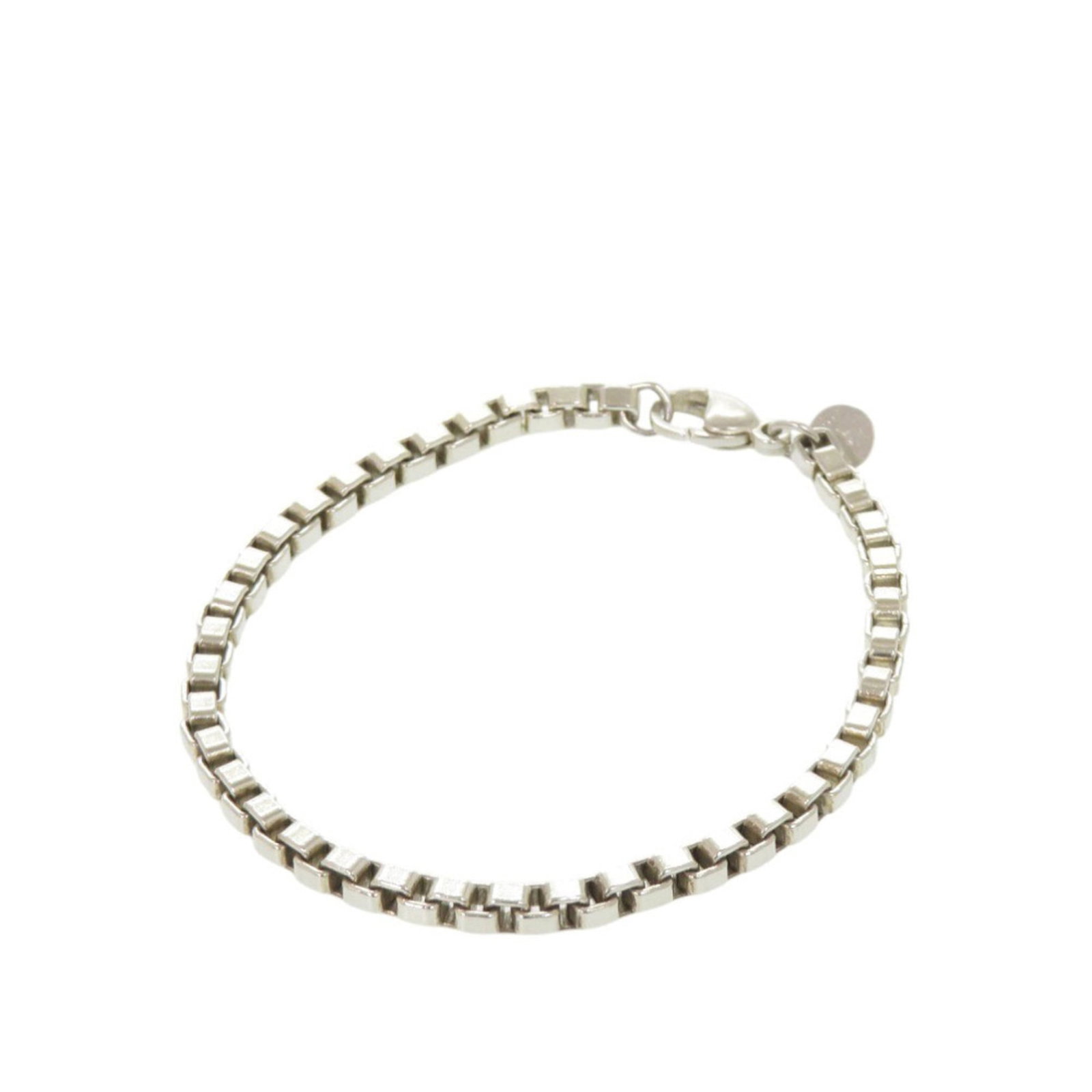 Silver Tiffany Link Bracelet: Silver Tiffany Link Bracelet Silver Tiffany Link Bracelet, featuring a classic design with a silver 925 material and 18cm length. This used bracelet shows traces of usage, with scratches and dirt visi