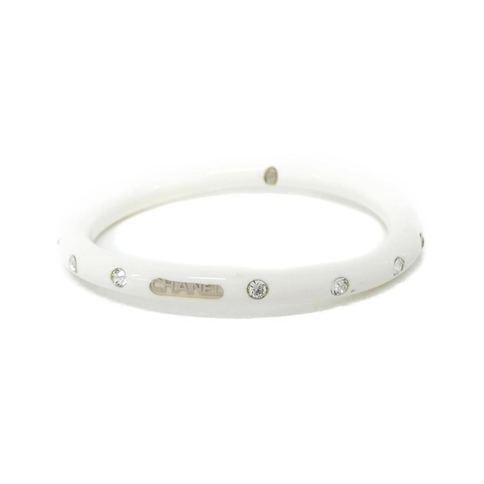 Bangle Chanel: Bangle Chanel This white Chanel bangle boasts a sleek design with a length of 20cm, making it a stylish addition to any outfit. With its classic look and durable construction, this piece has been