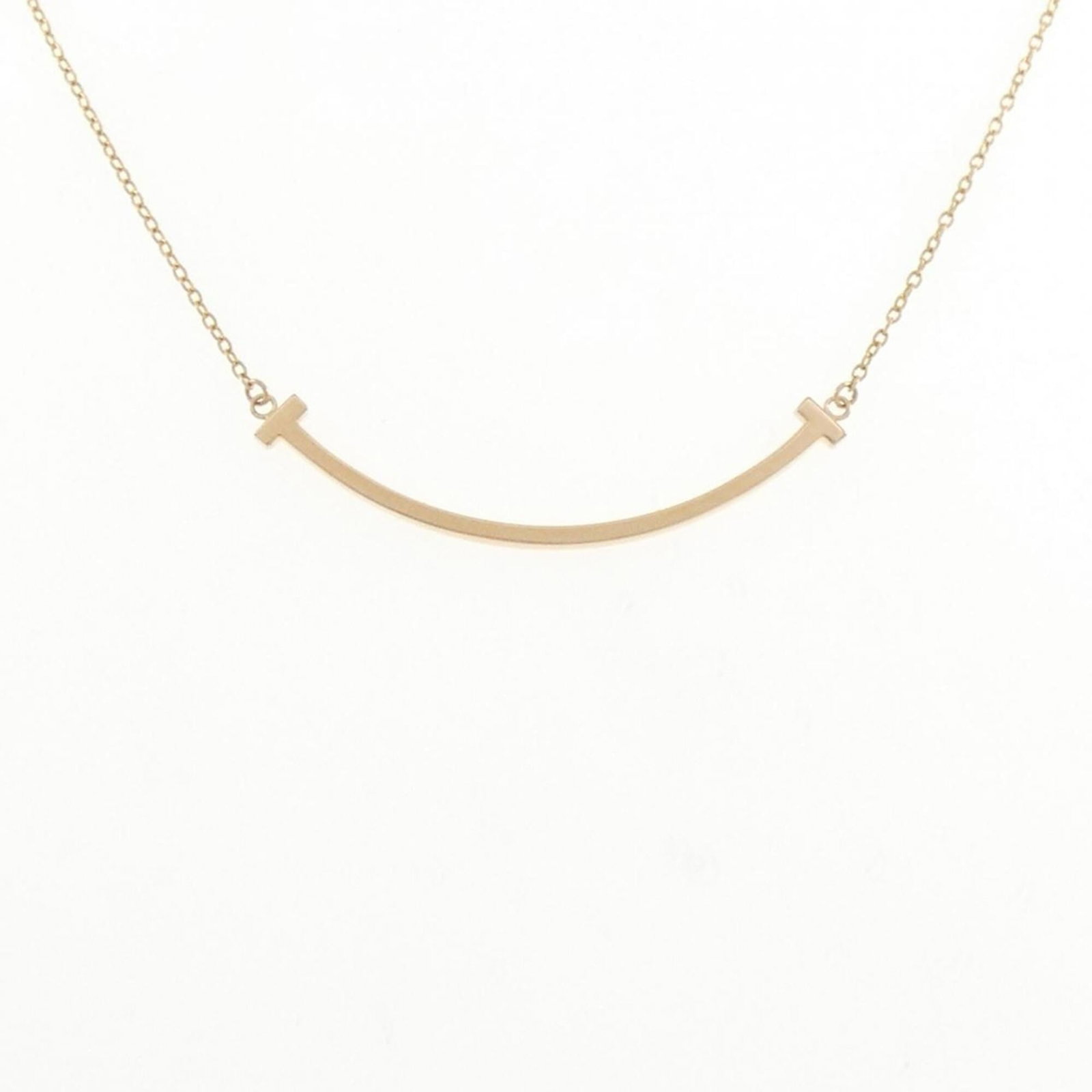 Smile of Tiffany T Necklace Small: Smile of Tiffany T Necklace Small Small, elegant pendant features a delicate pink gold (18K) design with a subtle shine. The necklace type is a classic Tiffany style, crafted from high-quality pink go