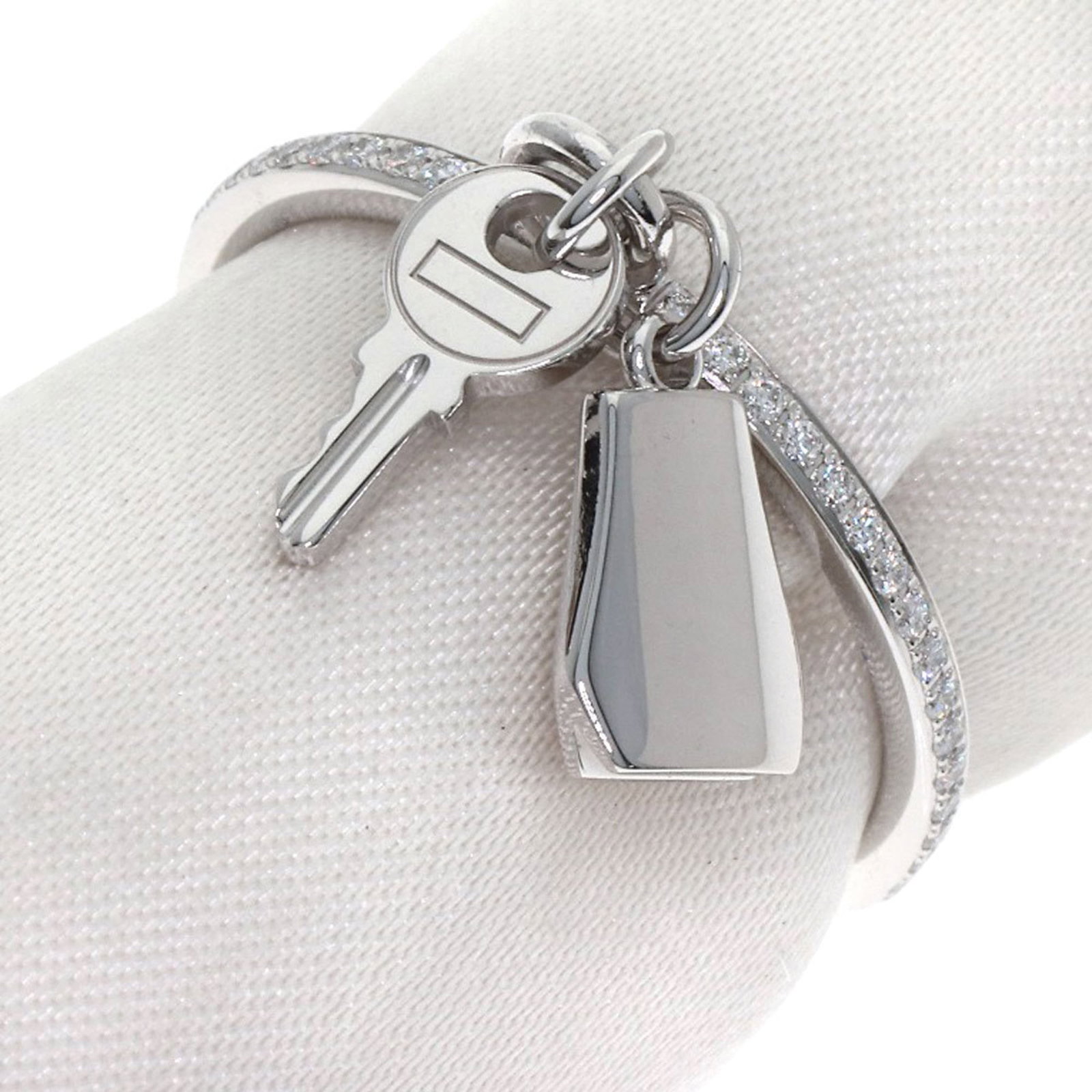 Hermes Band Ring White Gold (18K): Hermes Band Ring White Gold (18K) This Hermes band ring features white gold (18K) and a diamond stone, crafted in a classic design. The item has been worn and shows some signs of usage, with minor scr