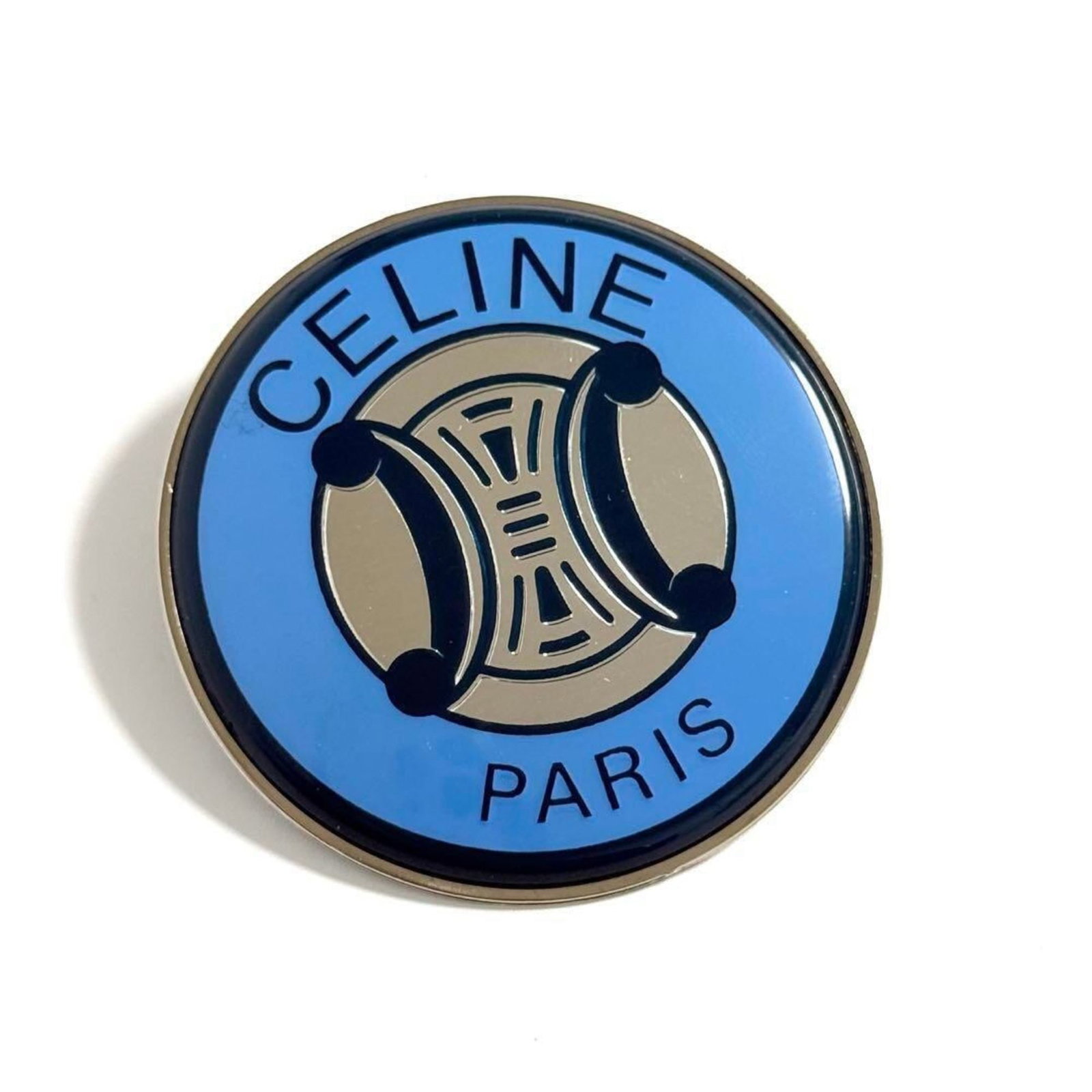 Metal Celine Brooch: Metal Celine Brooch Metal Celine Brooch, crafted from metal, features the iconic brand Celine. This brooch is in mint condition and like new, with no signs of wear. Its sleek design makes it a stylish