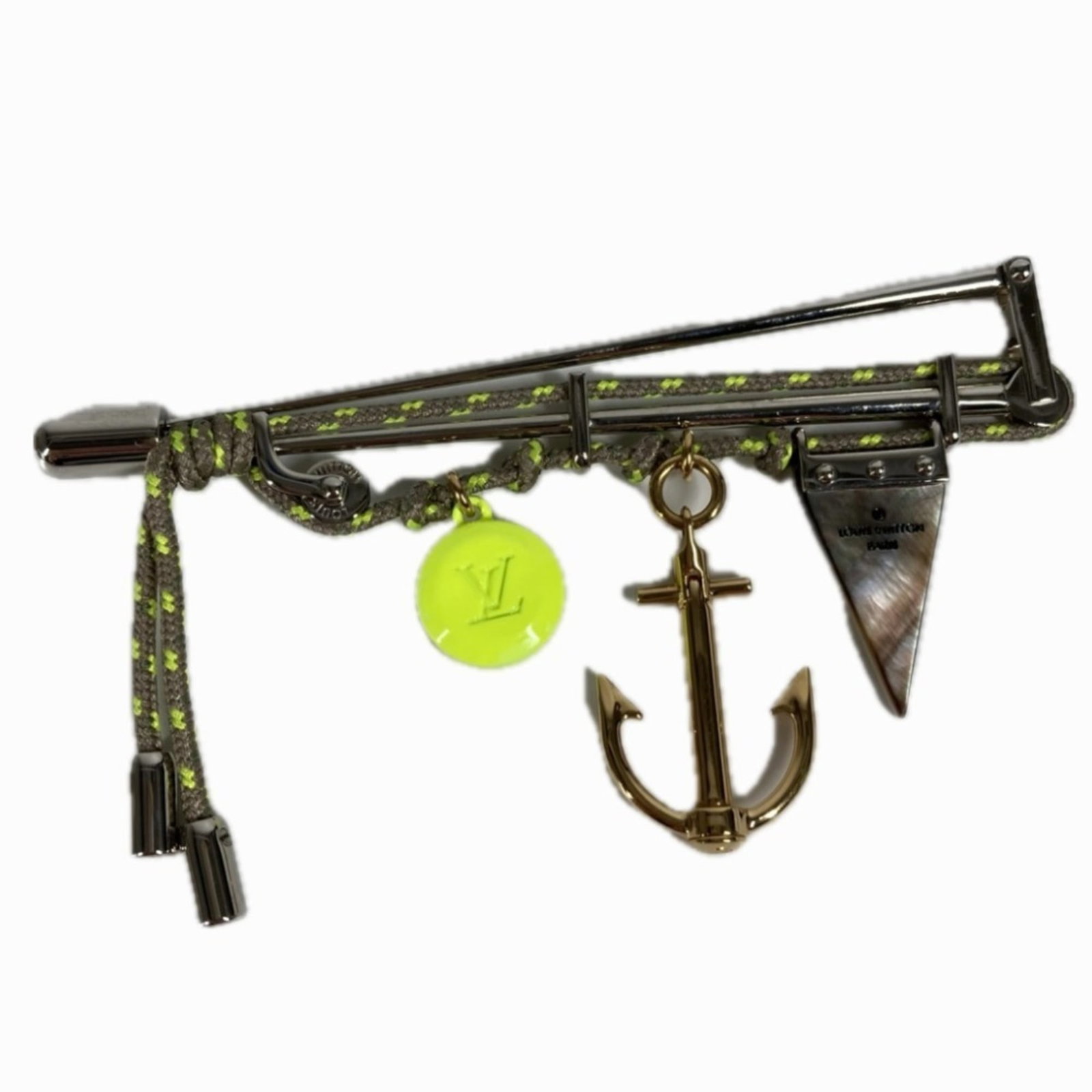 Louis Vuitton Brooch Pin Metal: Louis Vuitton Brooch Pin Metal This Louis Vuitton brooch pin features a silver metal design with subtle yellow tones, showcasing the iconic brand's signature style. The pin bears minor signs of use,
