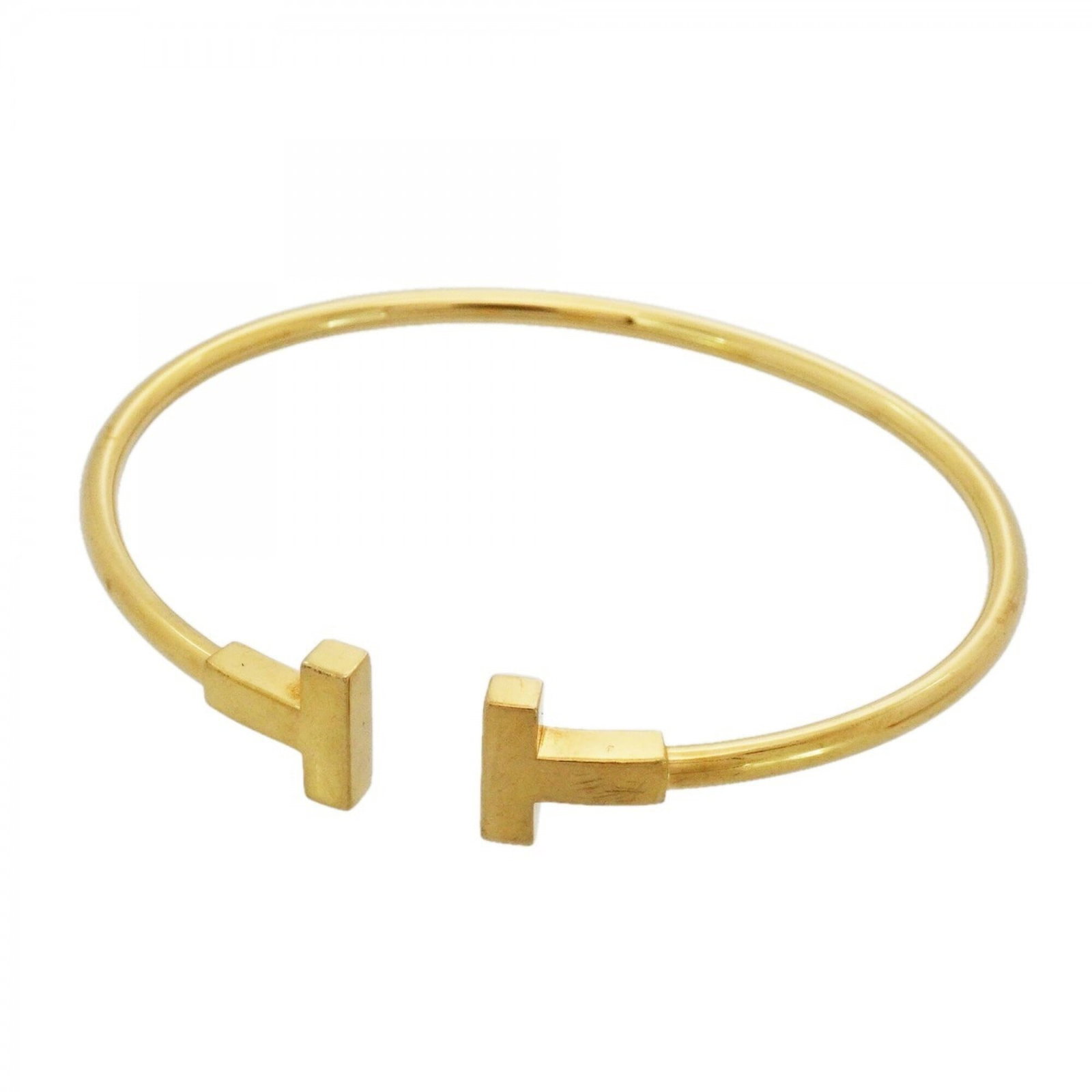 Yellow Gold Bangle Tiffany: Yellow Gold Bangle Tiffany Yellow Gold Bangle Tiffany features an 18K yellow gold construction with visible scratches and traces of usage. The bangle measures 15cm in length, offering a distinctive st
