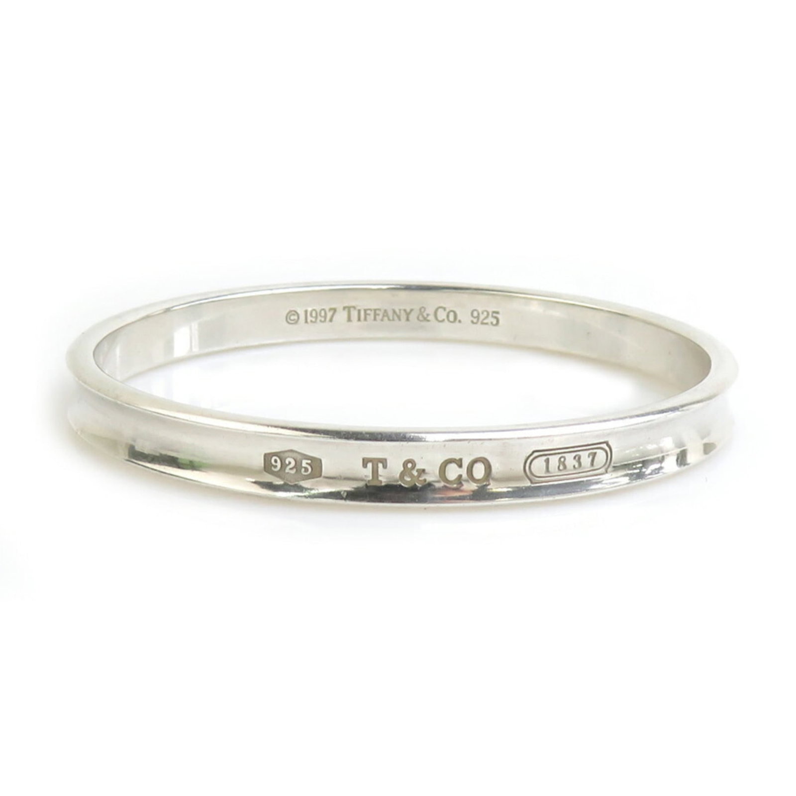Silver Bangle Tiffany: Silver Bangle Tiffany Silver Bangle Tiffany bears a signature, made from high-quality silver (925) and measuring 18cm in length. This used bangle has visible traces of usage, scratches, and dirt, but