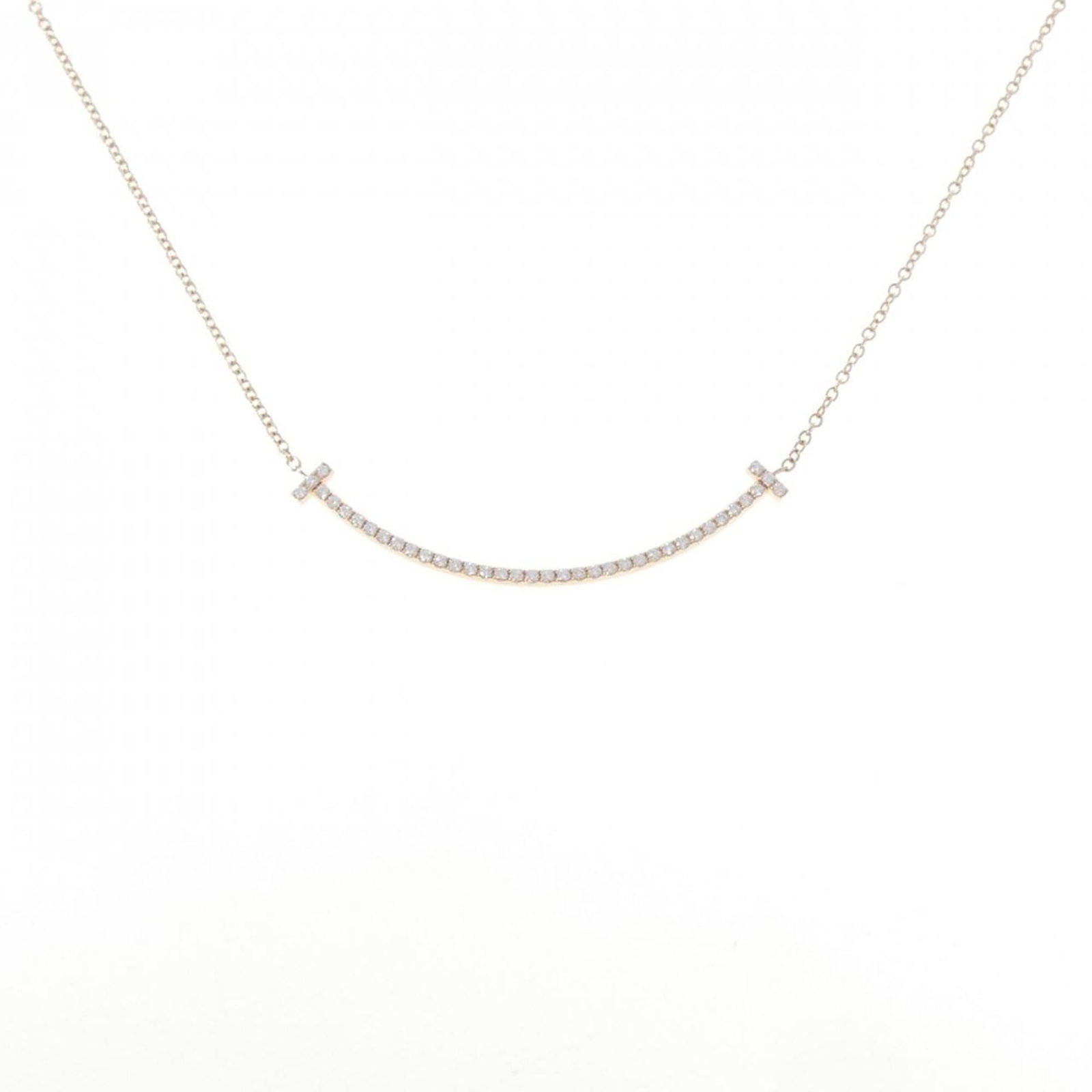 Smile of Tiffany T Necklace Small: Smile of Tiffany T Necklace Small Pink gold (18K) pendant featuring a small diamond, set on a necklace with a circumference of 40 cm. The pendant measures 3.6mm x 37mm and bears some minor scratches