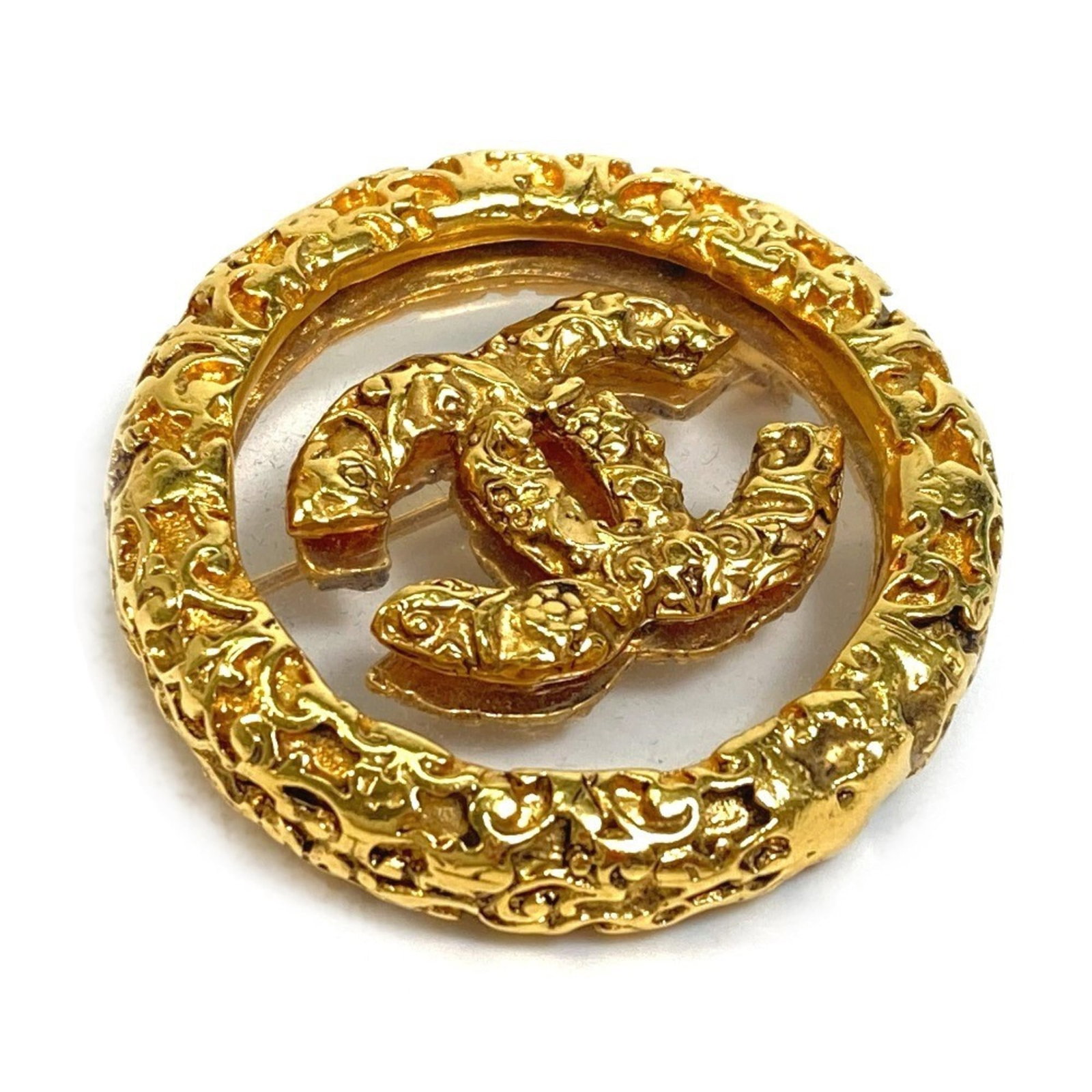 Metal brooch by Chanel: Metal brooch by Chanel A gold metal brooch by the renowned fashion house Chanel, bearing subtle signs of past use. Measuring 3.7cm x 3.7cm, its compact size makes it a versatile accessory for everyday