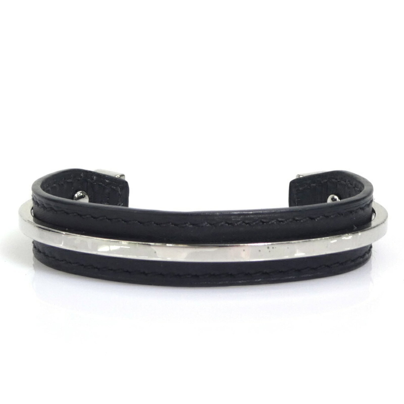Metal leather bangle Hermes: Metal leather bangle Hermes This black metal leather bangle from Hermes features a sleek, sophisticated design. Traces of usage are evident, with minor scratches and dirt visible, but overall it remai