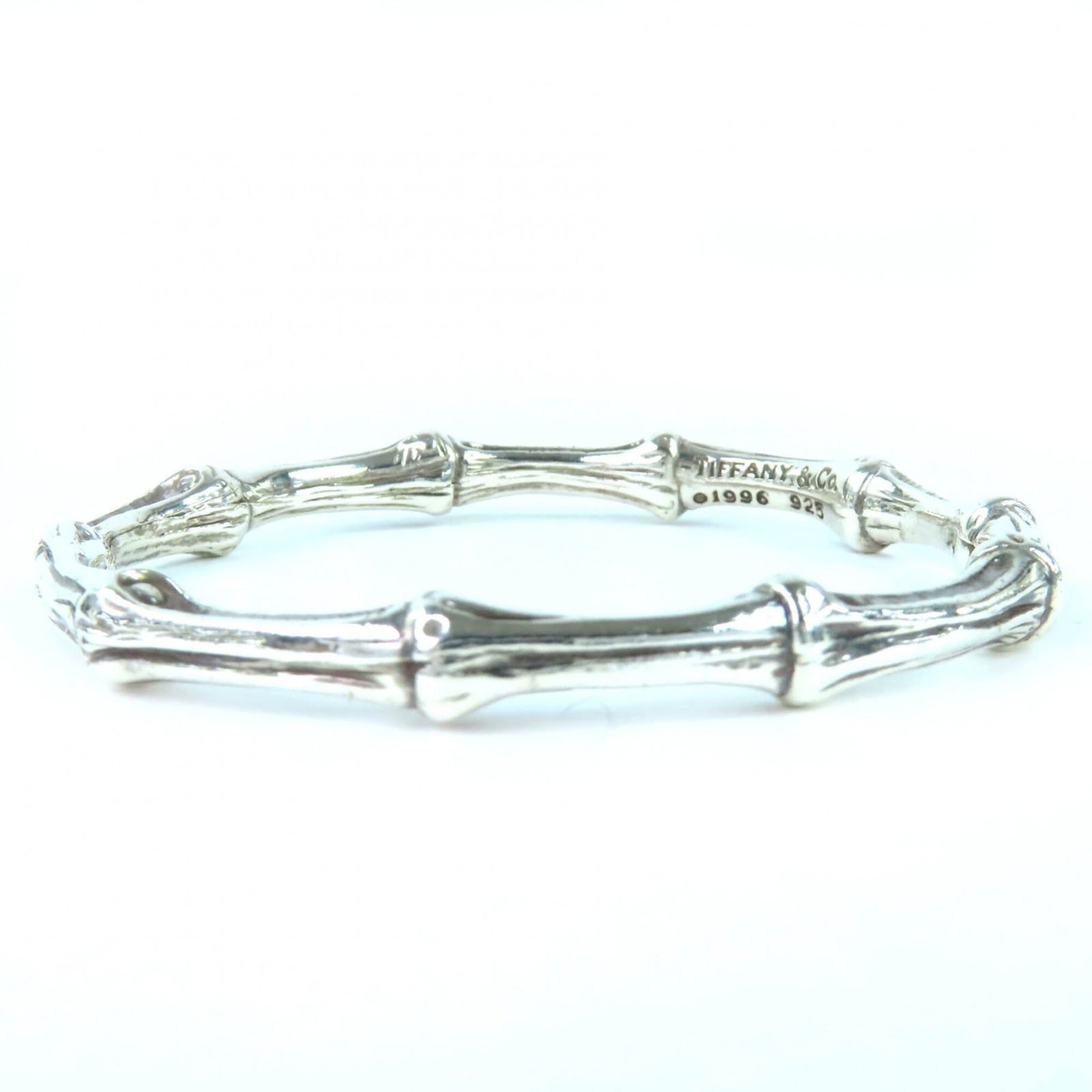 Tiffany Bangle: Tiffany Bangle Tiffany's iconic bangle, crafted from sterling silver (925), boasts a sleek design with a subtle width of 7mm. Measuring 19cm in length, this vintage piece exudes understated elegance. 