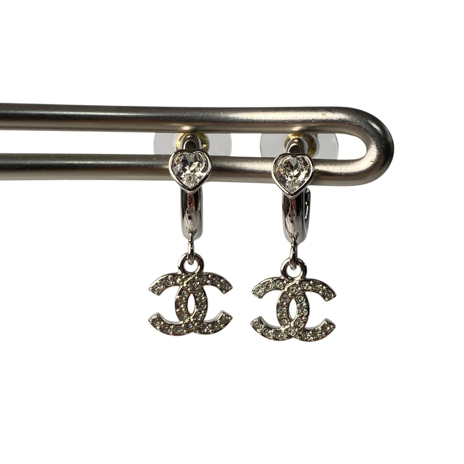 Chanel Stud Earrings: Chanel Stud Earrings Stud earrings from the iconic Chanel brand, featuring a sleek silver design. The earrings show some signs of usage, with a few traces of wear and minor scratches, but remain in ve