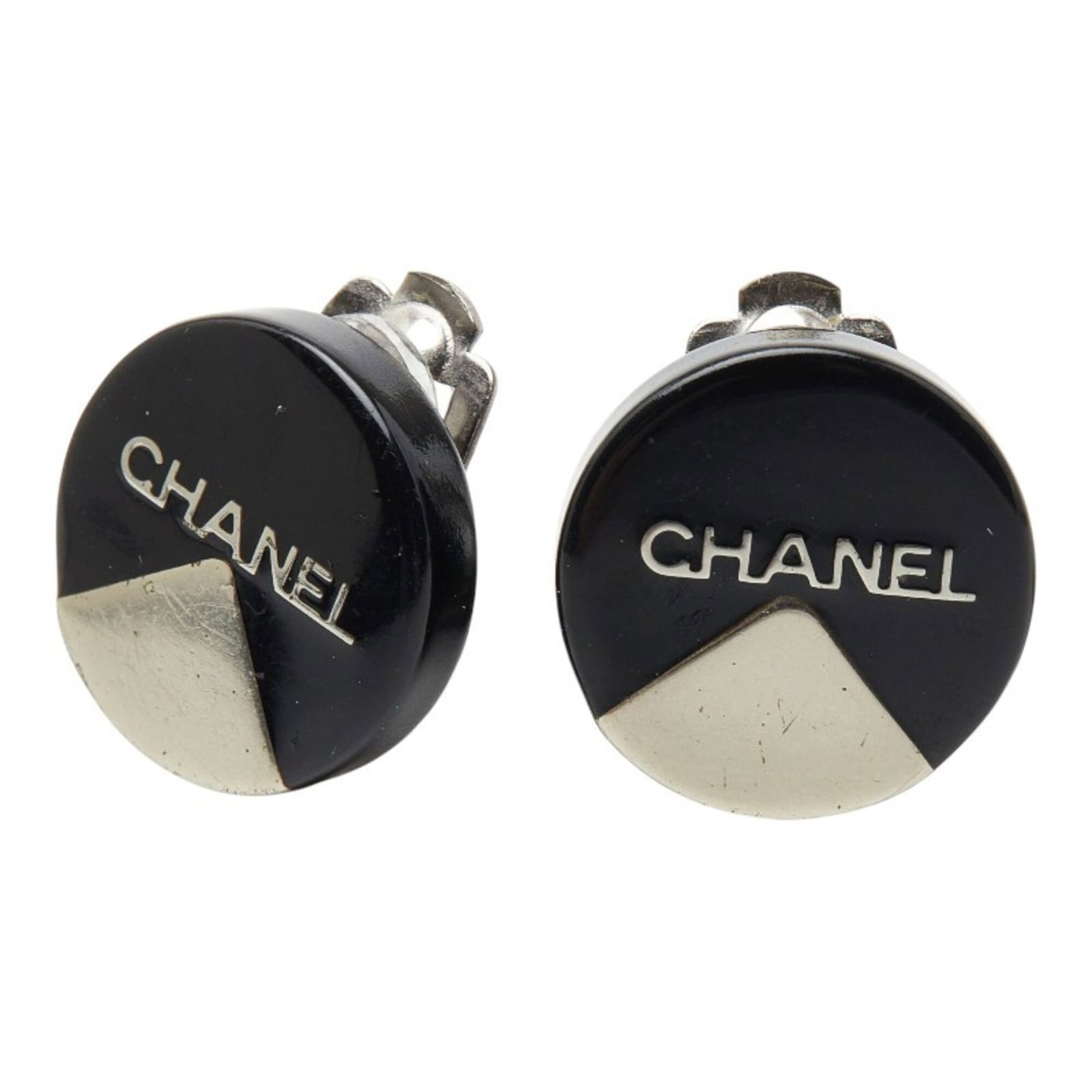 Metal clip earrings by Chanel: Metal clip earrings by Chanel Metal clip earrings by Chanel, featuring black and silver details, show signs of use with minor scratches and dirt. The condition is generally good despite some traces of