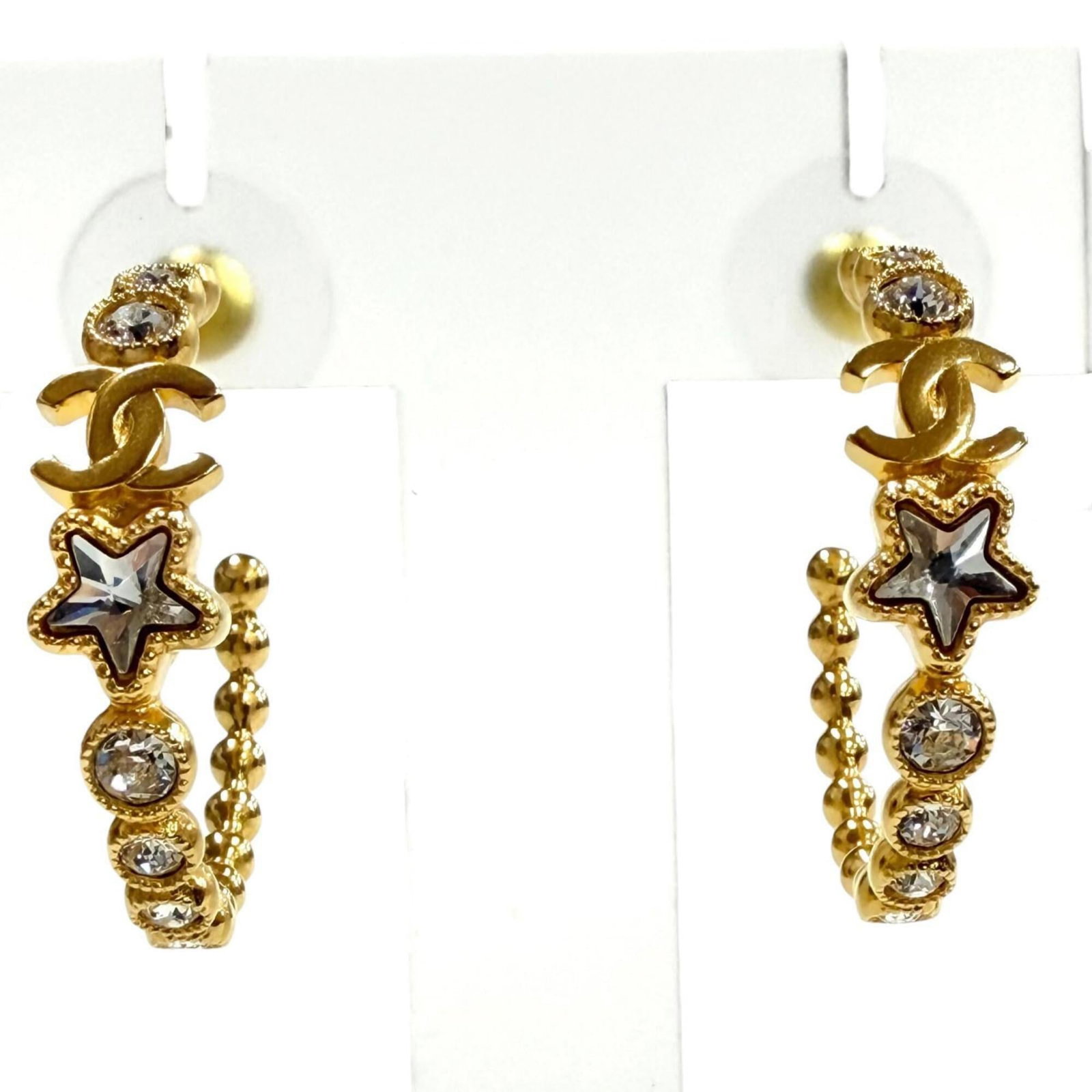 Hoop Earrings by Chanel: Hoop Earrings by Chanel Gold Crystal Hoop Earrings by Chanel, measuring 50.00mm x 7.00mm in size, feature crystal stones and a classic design. The earrings have been used but are in very good conditio