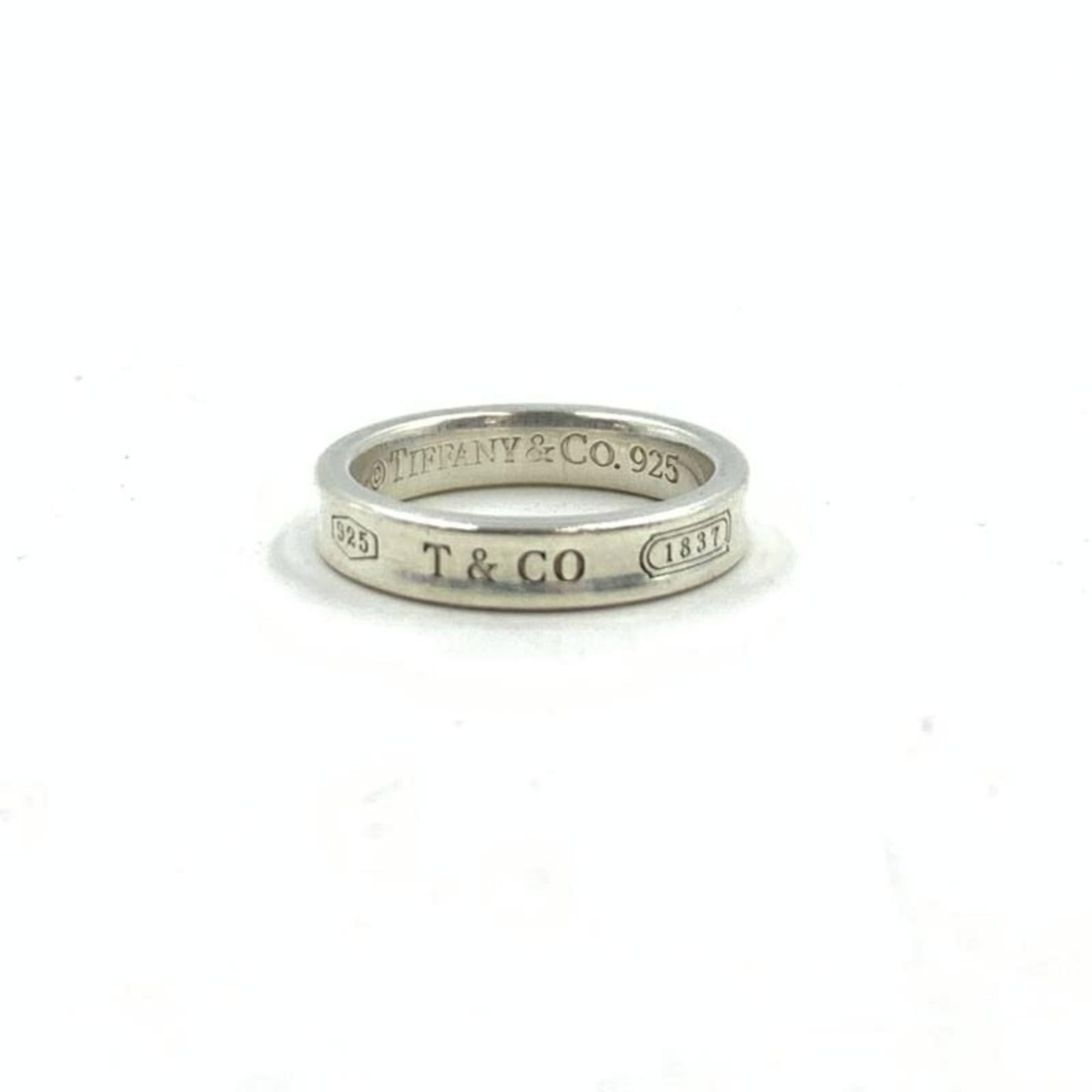 Tiffany & Co. 1837 Narrow Ring Sv925 60126383: Tiffany & Co. 1837 Narrow Ring Sv925 60126383 Silver Tiffany & Co. ring from 1837, featuring the narrow design and hallmark Sv925. The piece shows signs of use, with minor scratches and dirt visible, 