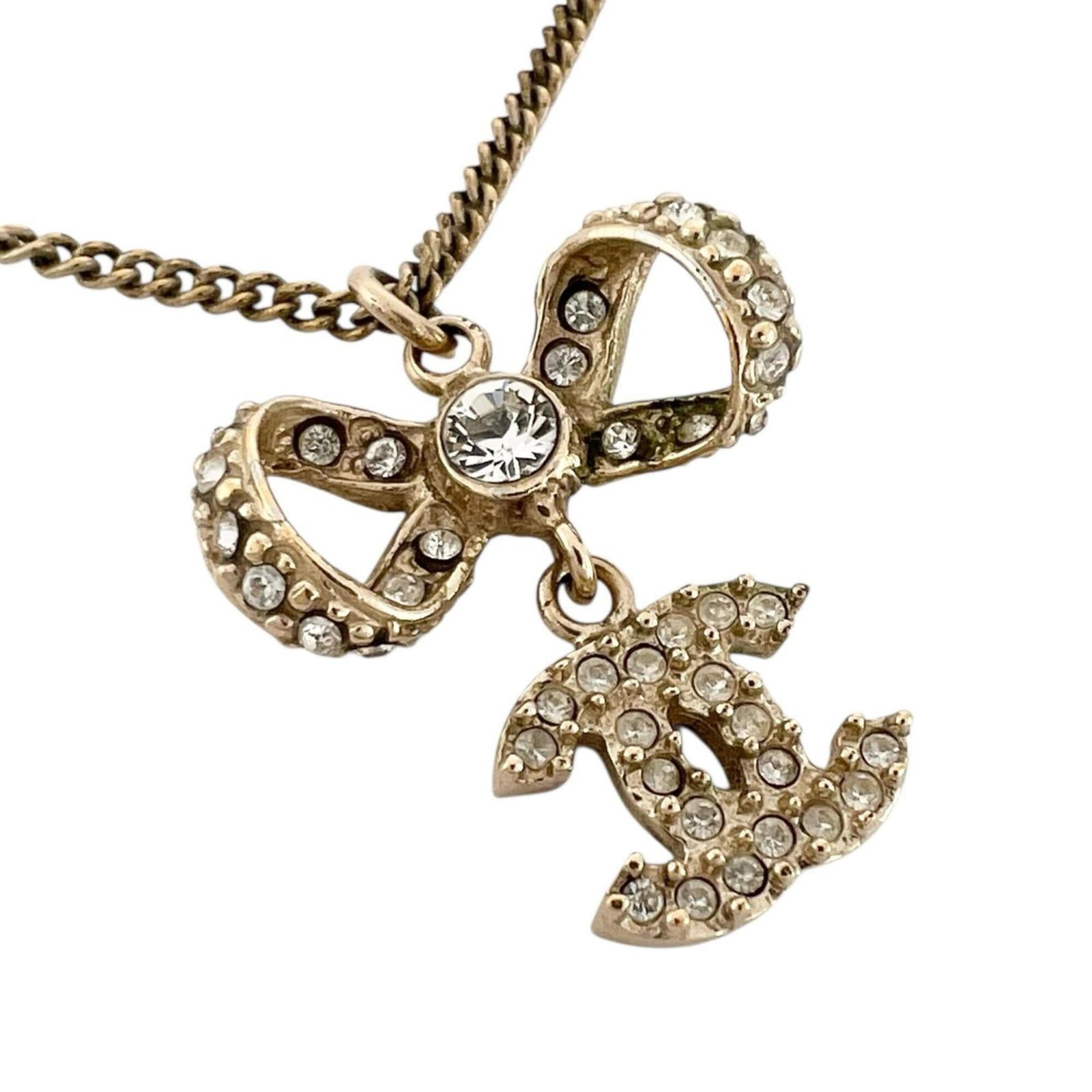 Crystal plated gold necklace ribbon motif women's Coco Chanel mark: Crystal plated gold necklace ribbon motif women's Coco Chanel mark Gold plated gold necklace ribbon motif bears the iconic Coco Chanel mark, adding a touch of timeless elegance to any outfit. The