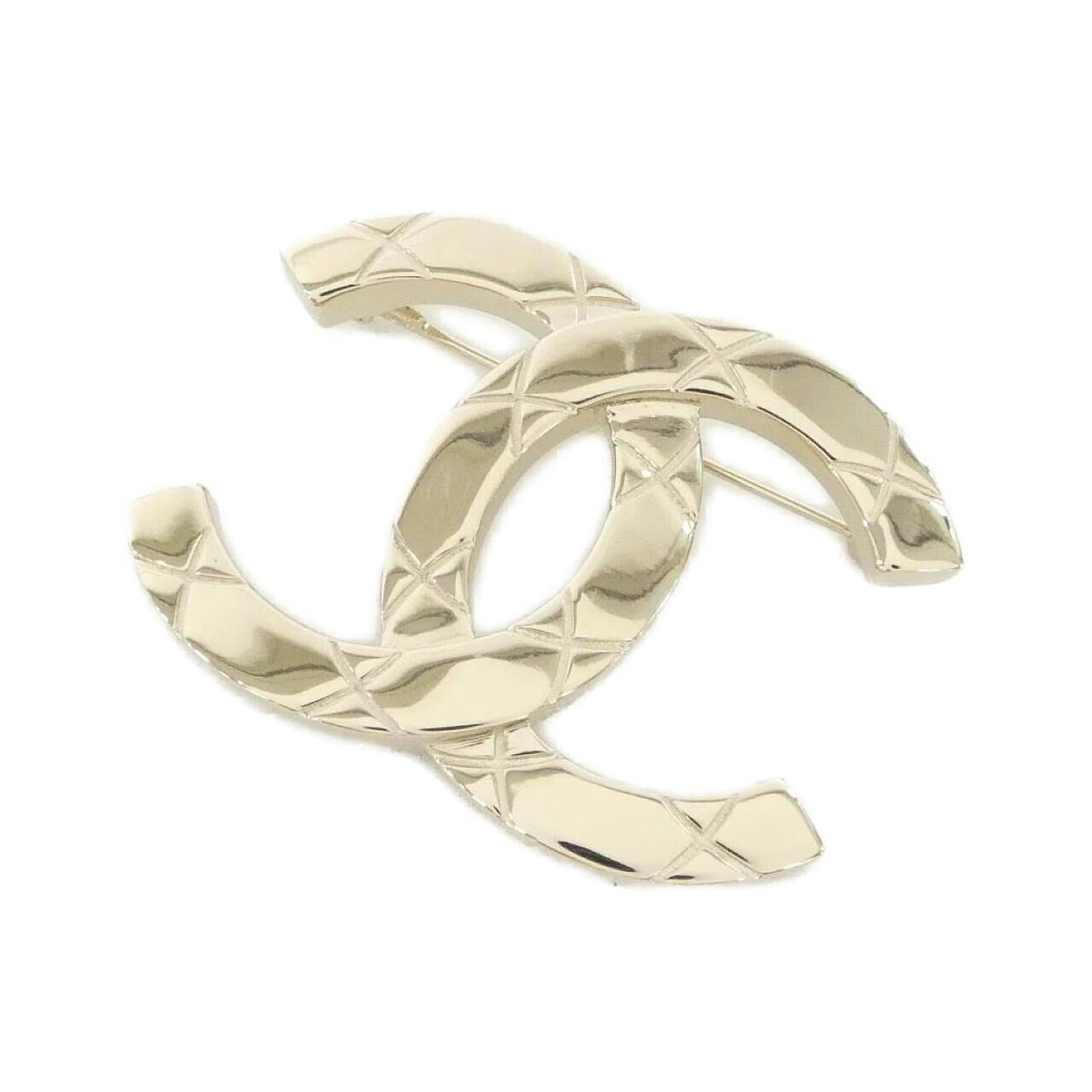 Chanel Brooch: Chanel Brooch Chanel Brooch in Gold. This used brooch features a gold finish and bears a signature, measuring 3.6cm x 4.8cm. It has a few traces of usage with some scratches / dirt, but remains in