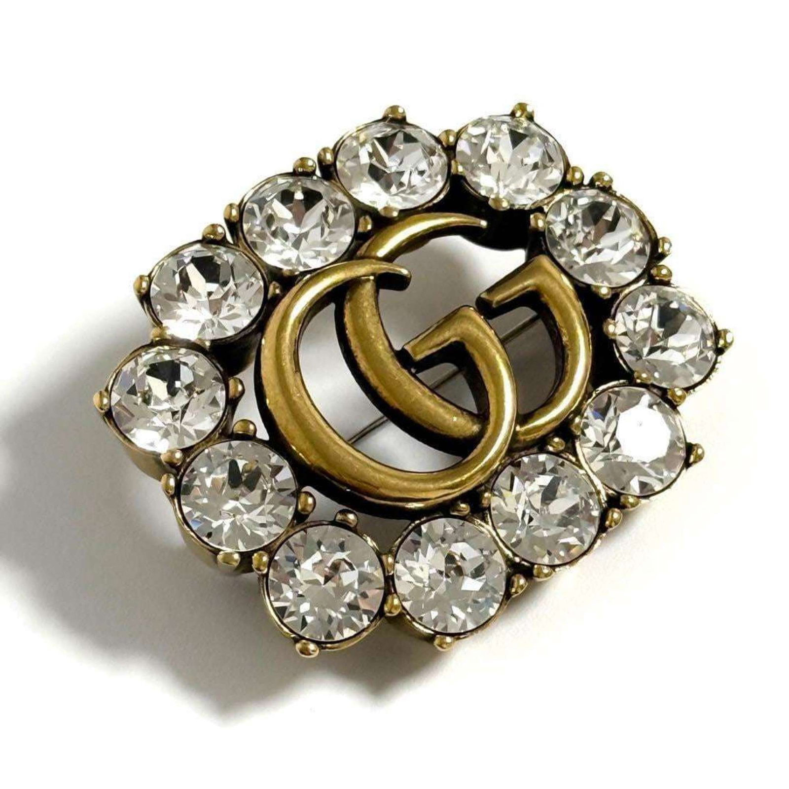 Metal brooch Gucci rhinestone: Metal brooch Gucci rhinestone Metal brooch featuring Gucci rhinestones, measuring 3.7cm x 4.5cm in size, with a few traces of usage and some scratches / dirt visible but overall in very good condition
