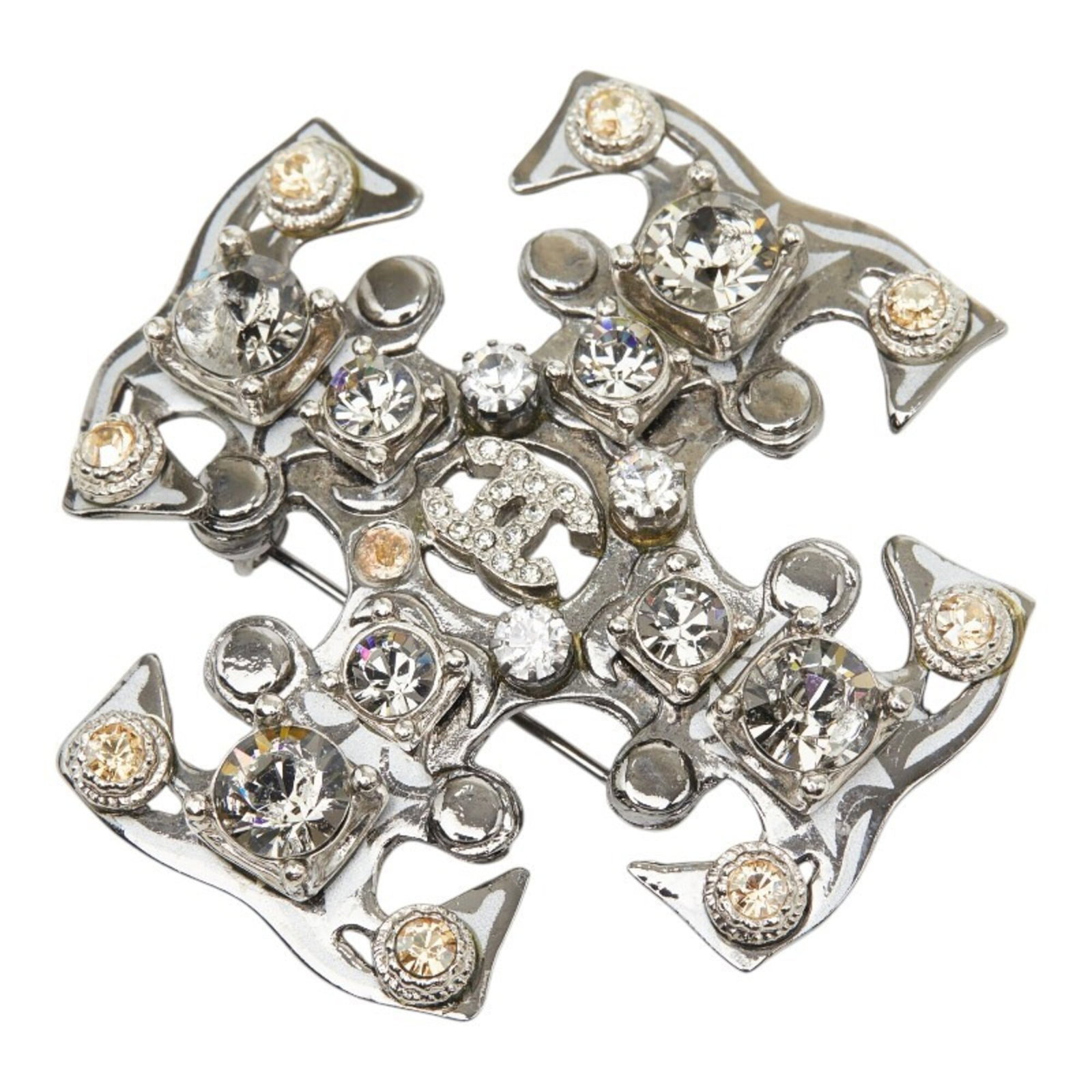 Metal brooch by Chanel: Metal brooch by Chanel Silver Chanel brooch featuring a rhinestone, measuring 5.1cm x 5.1cm in size, with traces of usage and minor scratches visible. The metal brooch bears a signature but details