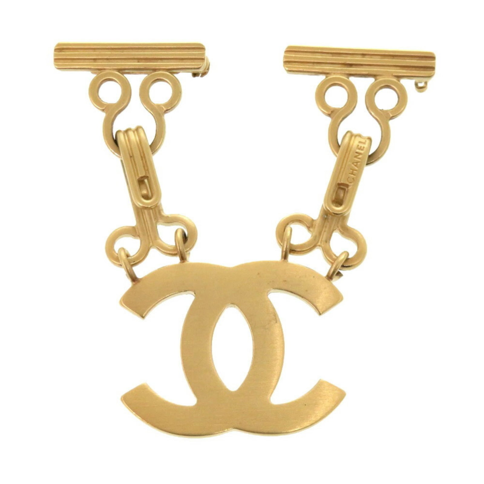 Metal brooch by Chanel: Metal brooch by Chanel Gold metal brooch by renowned fashion house Chanel, bearing subtle signs of use and minor scratches. The brooch's elegant design remains intact despite its age, showcasing the