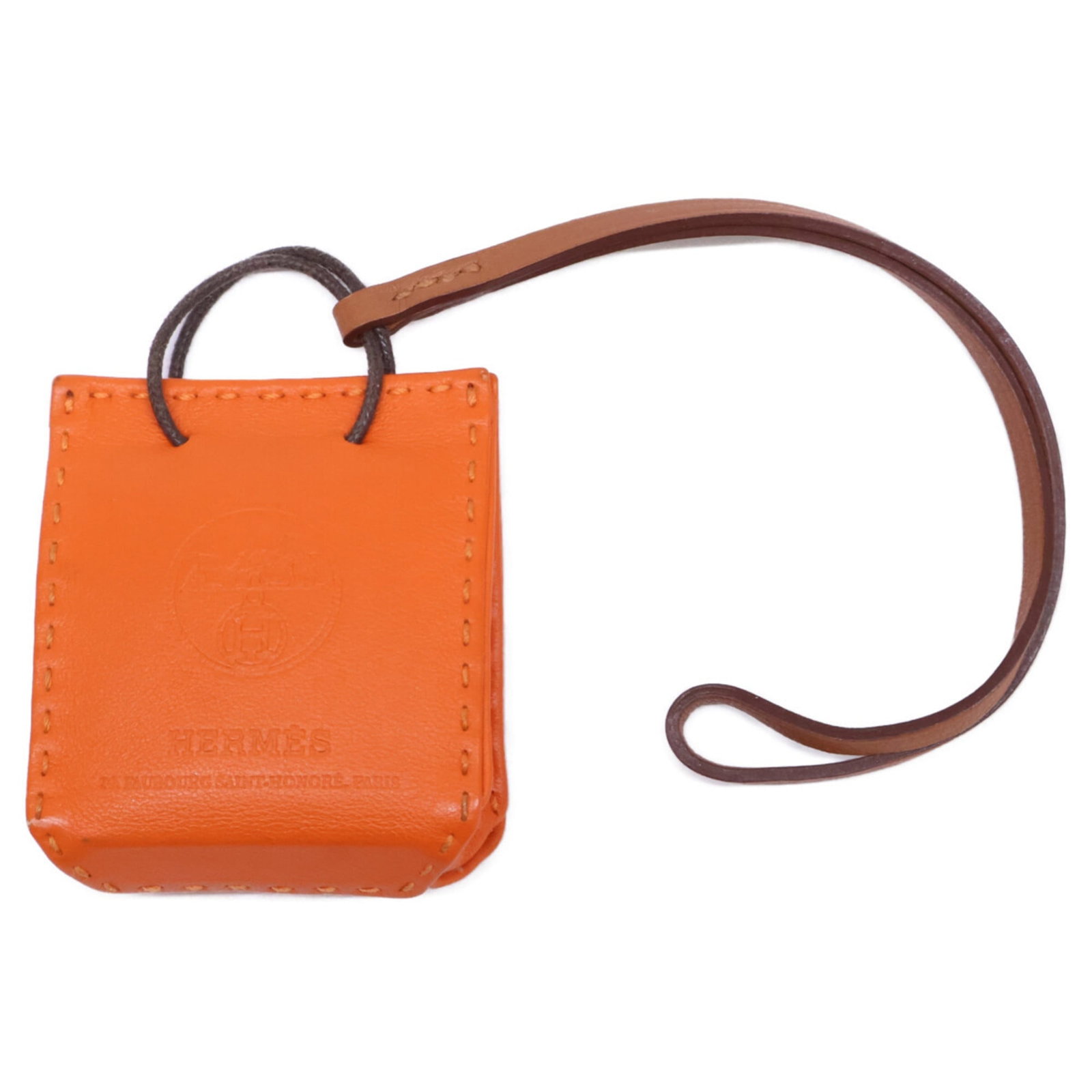 Hermes handbag charm leather: Hermes handbag charm leather Used Hermes handbag charm made from high-quality leather, featuring an orange color and some scratches/dirt. The item bears a signature but its origin cannot be confirmed.
