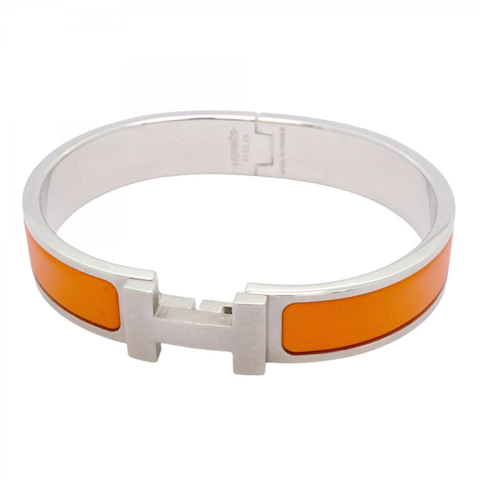 Metal Bangle Hermes: Metal Bangle Hermes This used metal bangle from Hermes features an orange and silver design, measuring 16.5cm in length. With visible traces of usage and minor scratches, it showcases a worn-in look