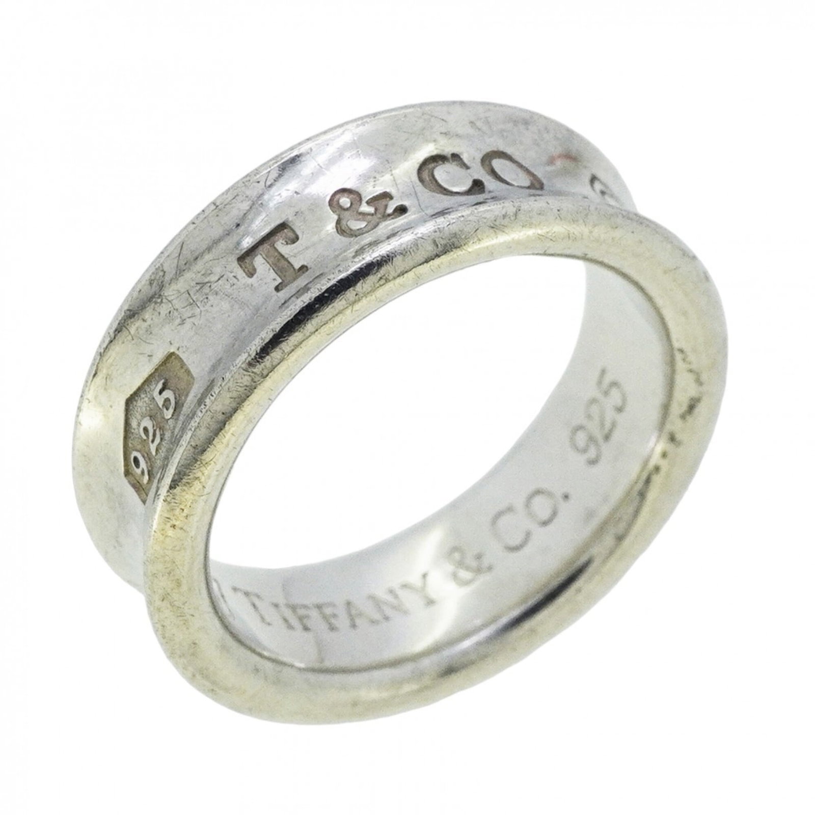 Tiffany Band Ring Silver 925: Tiffany Band Ring Silver 925 Silver 925 band ring from Tiffany, featuring a classic design with subtle wear and minor scratches. The item bears the Tiffany mark and has been used, showing signs of eve