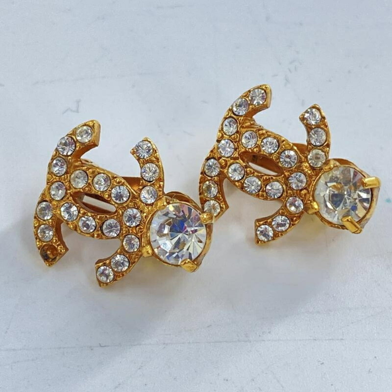 Chanel Clip Earrings: Chanel Clip Earrings Chanel Clip Earrings in Gold with Rhinestone Accents. These elegant earrings feature a classic clip design with a touch of luxury, boasting a gold finish and sparkling rhinestone