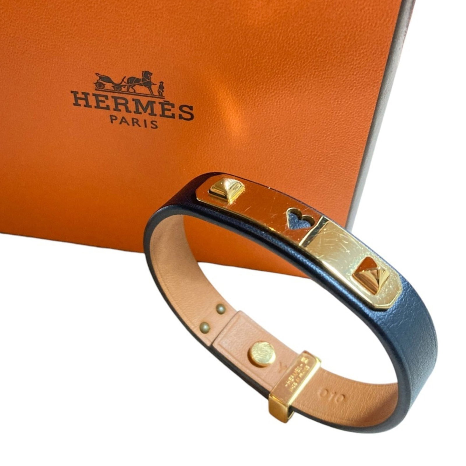 Hermes Leather Charm Swift Bracelet: Hermes Leather Charm Swift Bracelet Navy swift leather wraps around the wrist in an elegant, understated design. This pre-owned Hermes charm bracelet boasts a classic look with subtle signs of wear, a
