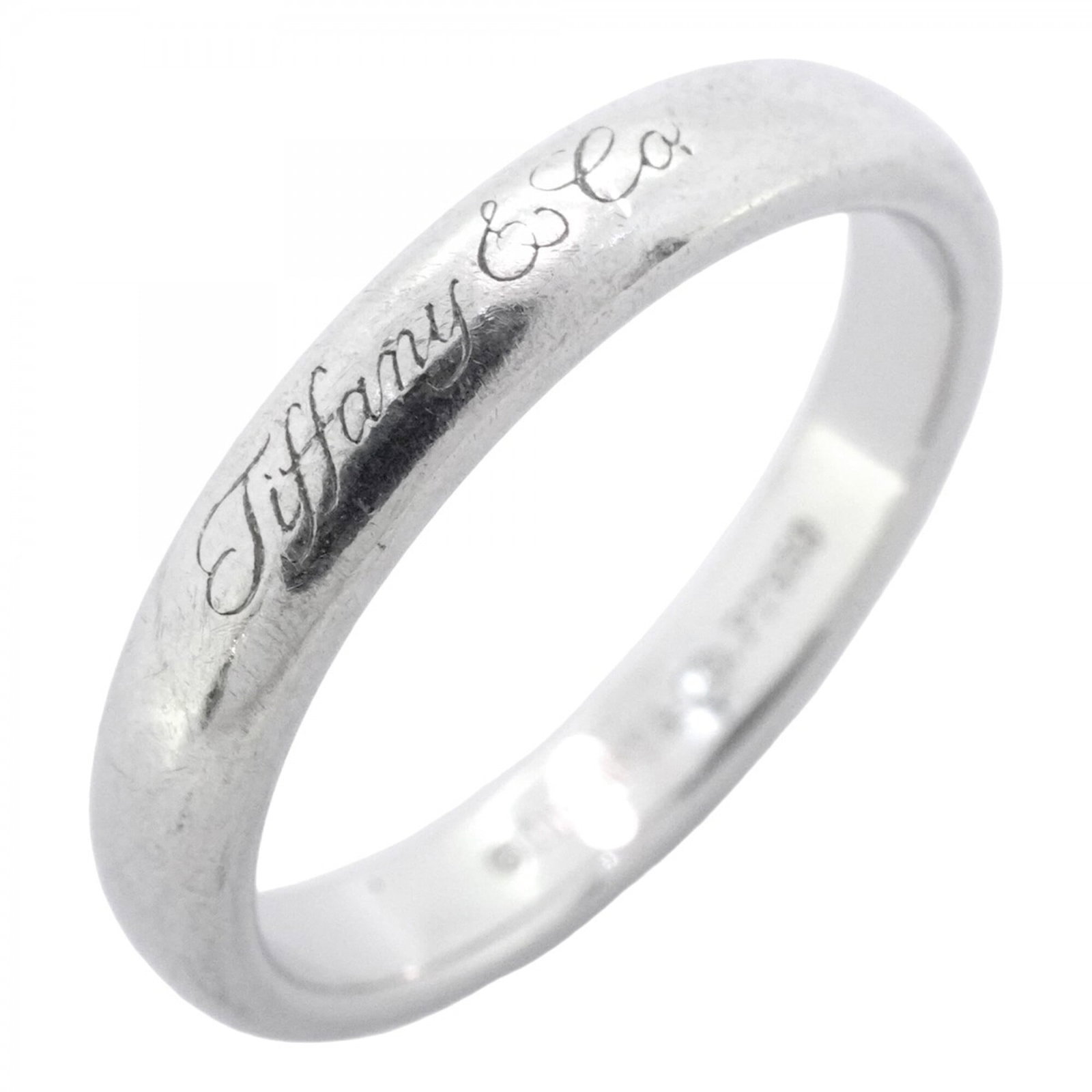 Platinum ring by Tiffany band: Platinum ring by Tiffany band Platinum ring by Tiffany features a band design made from high-quality platinum, with a 950 fine material. The item bears a signature and is in used condition, showing tr