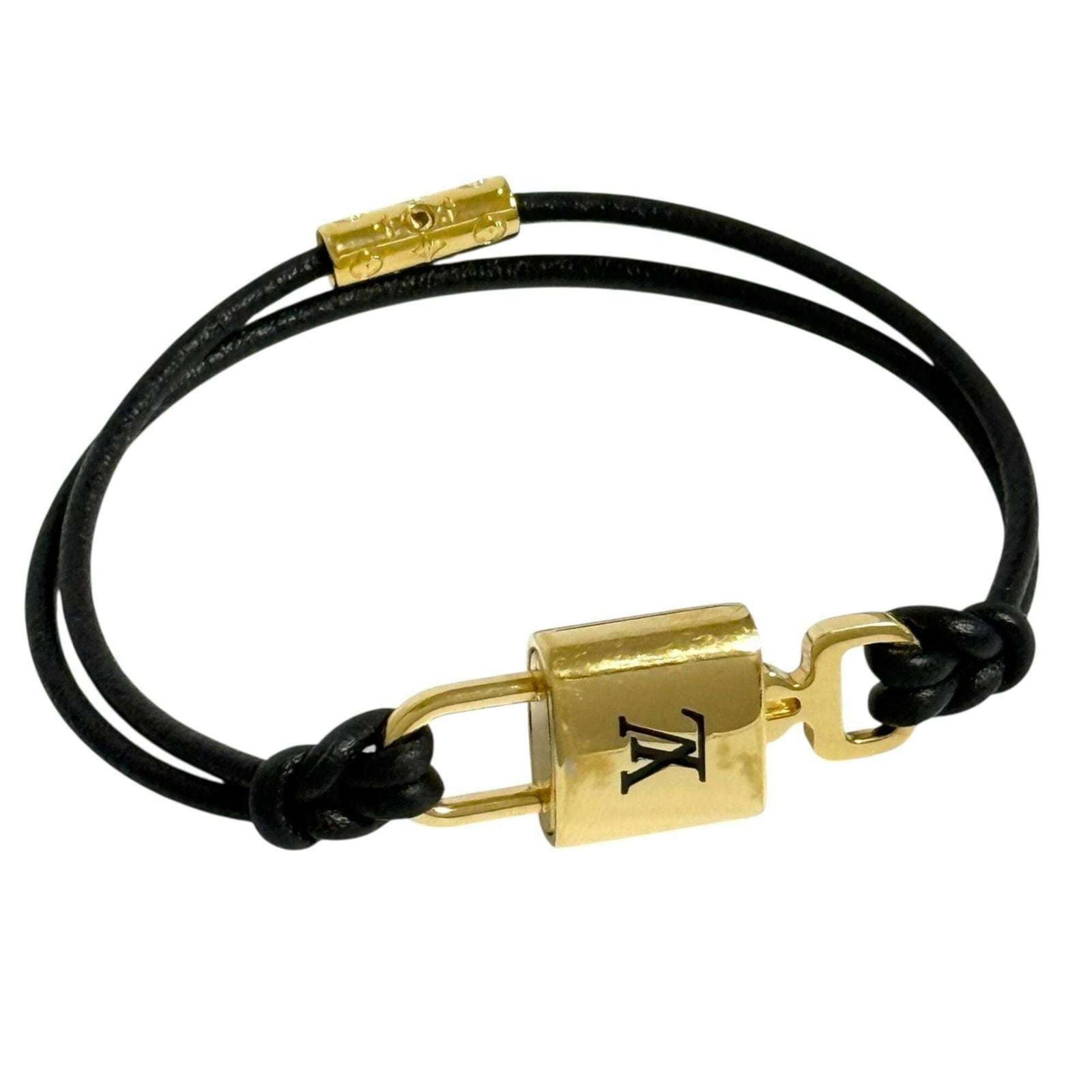 Metal Leather Charm Bracelet By Louis Vuitton: Metal Leather Charm Bracelet By Louis Vuitton Black leather and metal charm bracelet from Louis Vuitton, featuring a sleek design with subtle scratches and dirt. The bracelet measures 15.5cm in