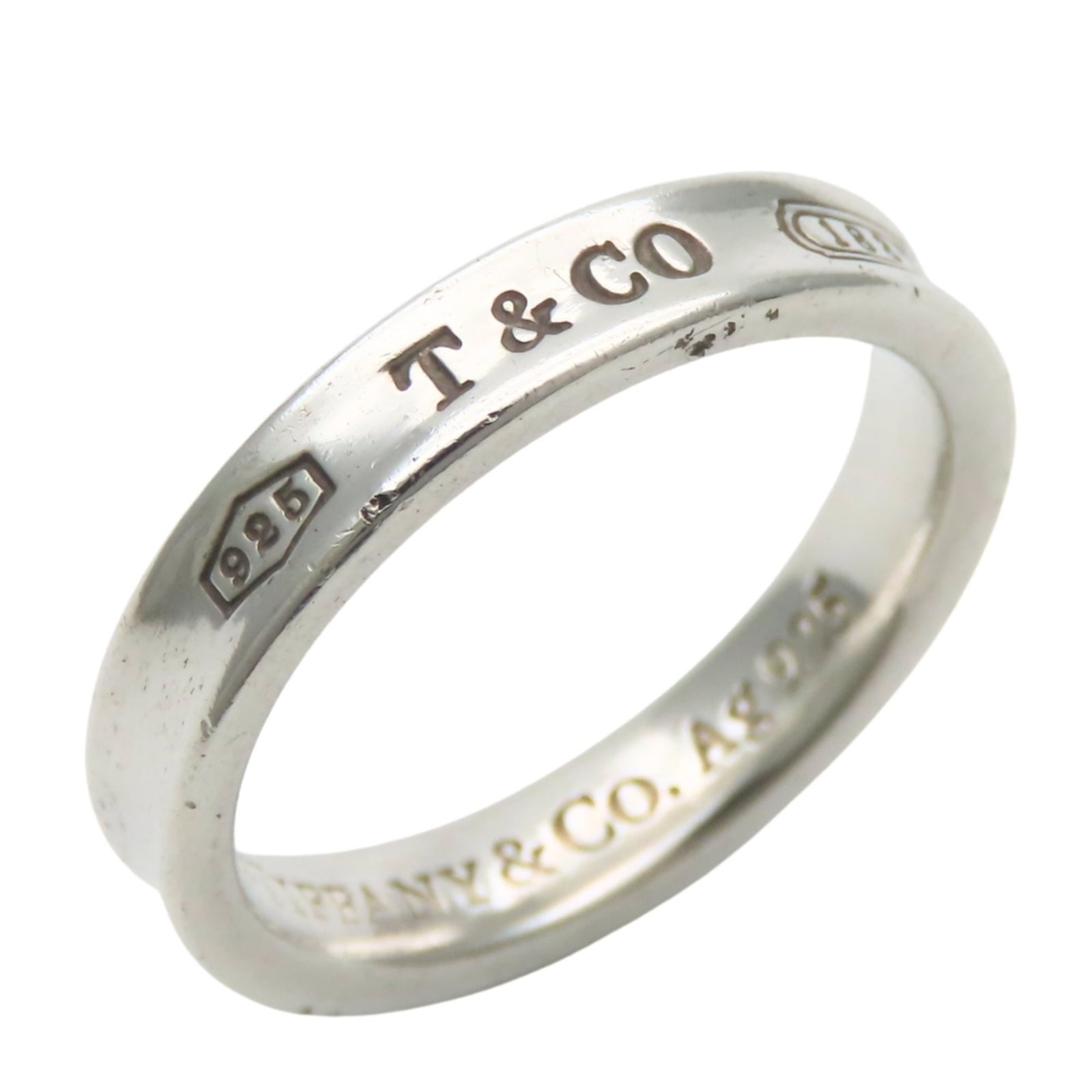 Tiffany Band Ring Silver 925: Tiffany Band Ring Silver 925 Silver 925 band ring from Tiffany, featuring a classic design with subtle scratches and signs of usage. This pre-owned item remains in good condition, showcasing the