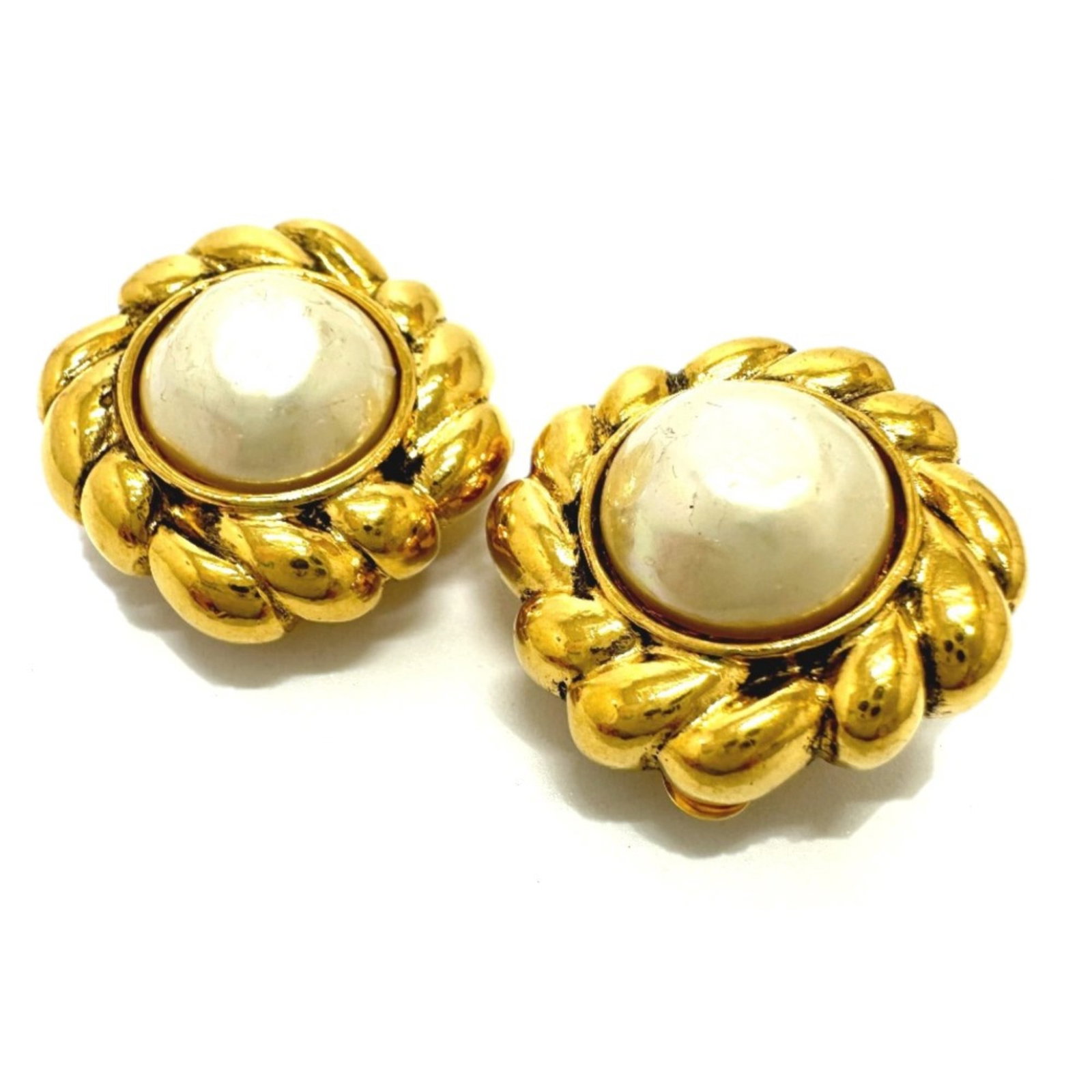 Clip earrings by Chanel: Clip earrings by Chanel Gold clip earrings by Chanel, featuring the iconic interlocking CC design. The earrings measure 2.5mm x 2.5mm and show signs of gentle use, with minor scratches and dirt visibl