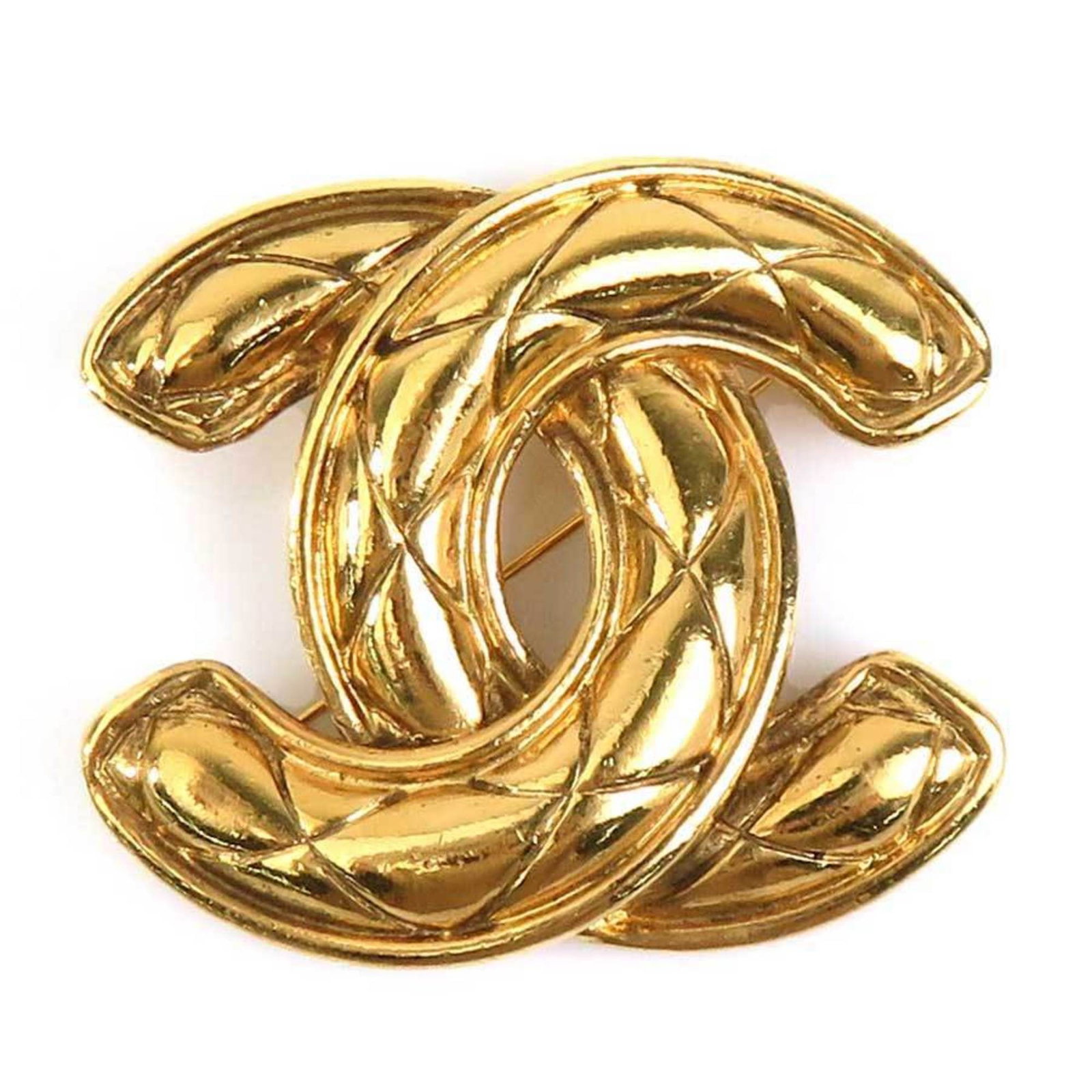 Metal brooch by Chanel: Metal brooch by Chanel This gold metal brooch by Chanel features a classic design with a subtle elegance. With its 5cm x 5.6cm size and traces of usage, it showcases the wear and tear that comes with