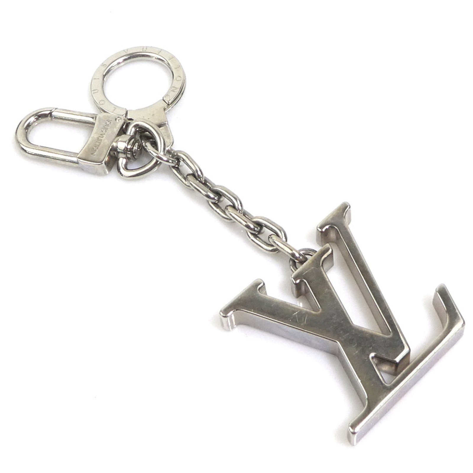 Metal Charm Vuitton Louis Keyring: Metal Charm Vuitton Louis Keyring Silver Metal Charm Vuitton Louis Keyring, featuring the iconic Louis Vuitton design, bears a signature. The keyring has traces of usage and minor scratches, but
