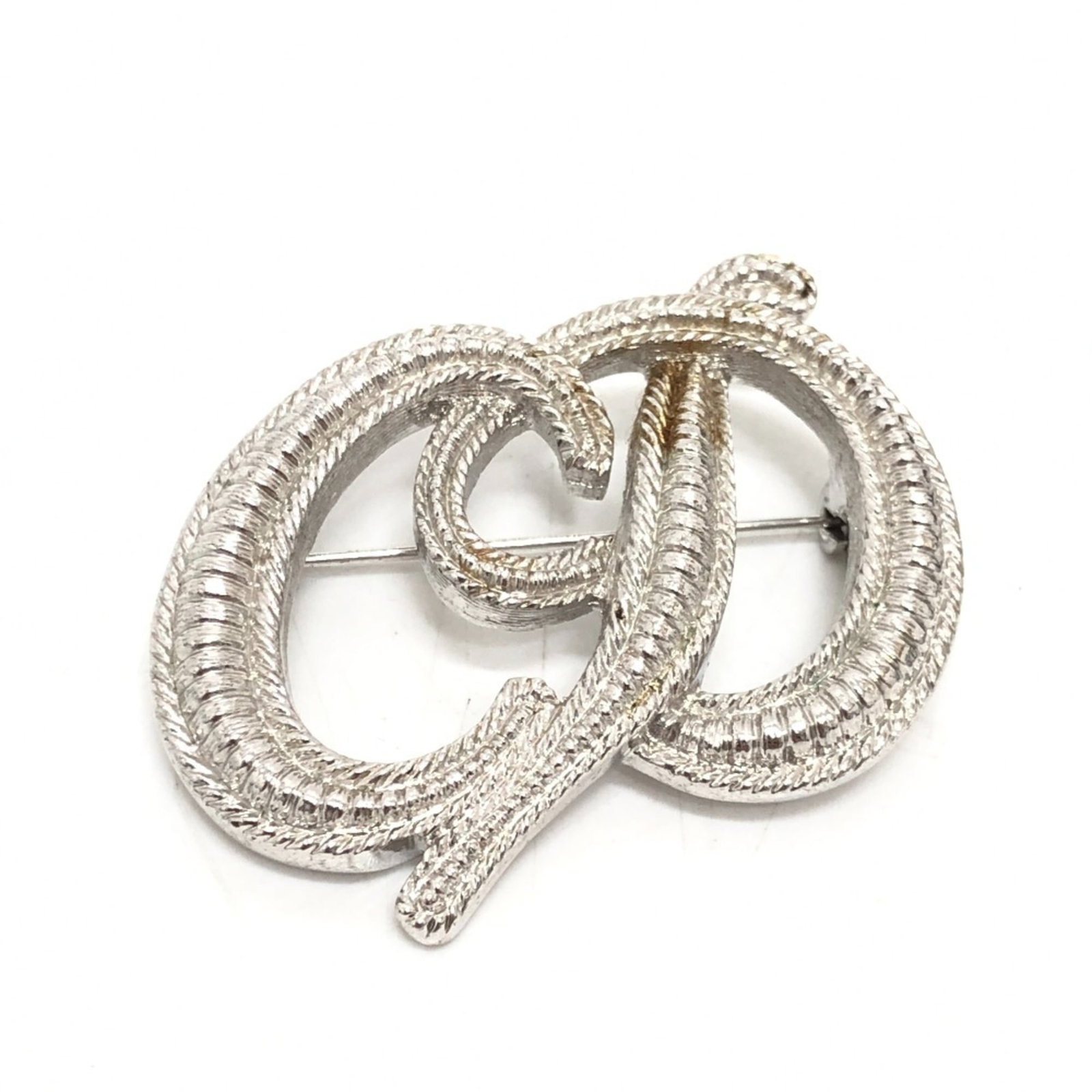 Christian Dior Brooch Metal: Christian Dior Brooch Metal The Christian Dior brooch metal features a sleek silver design, measuring 3.5cm x 4.5cm in size. With its subtle wear and tear visible, this piece still retains an air of