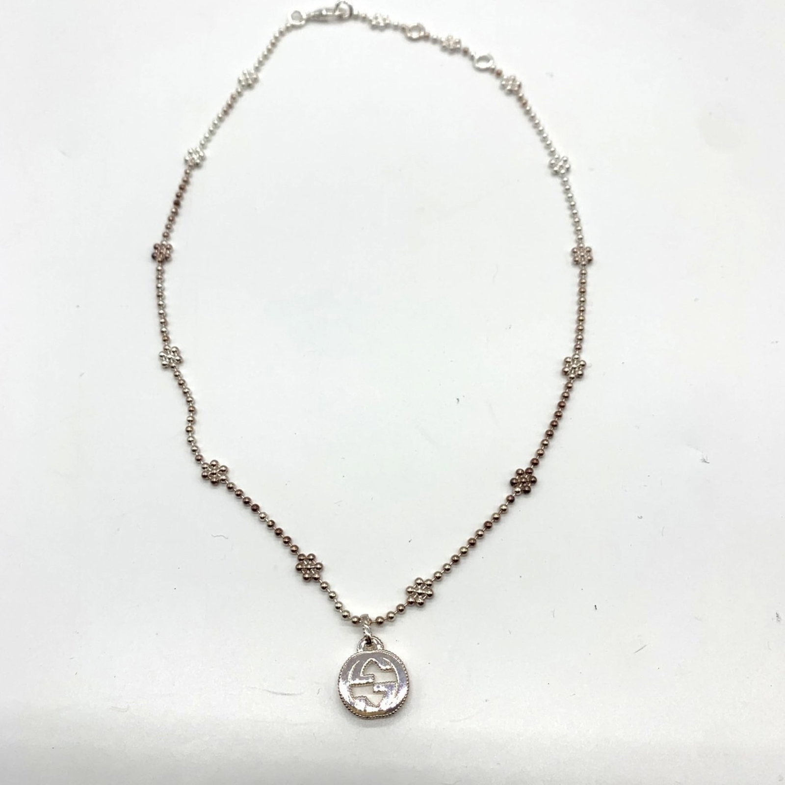 Sterling silver interlocking G flower necklace for women's: Sterling silver interlocking G flower necklace for women's Sterling silver interlocking G flower necklace for women features an elegant design. The necklace boasts Gucci branding, showcasing the