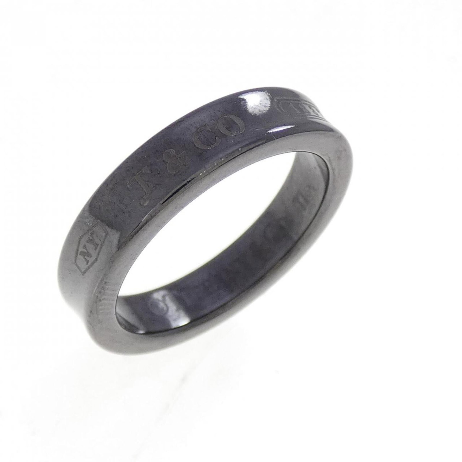 Tiffany Band Ring Titanium: Tiffany Band Ring Titanium Used Tiffany Band Ring in Titanium, with a few traces of usage visible. The ring bears some scratches and dirt but remains in very good condition overall. A notable example