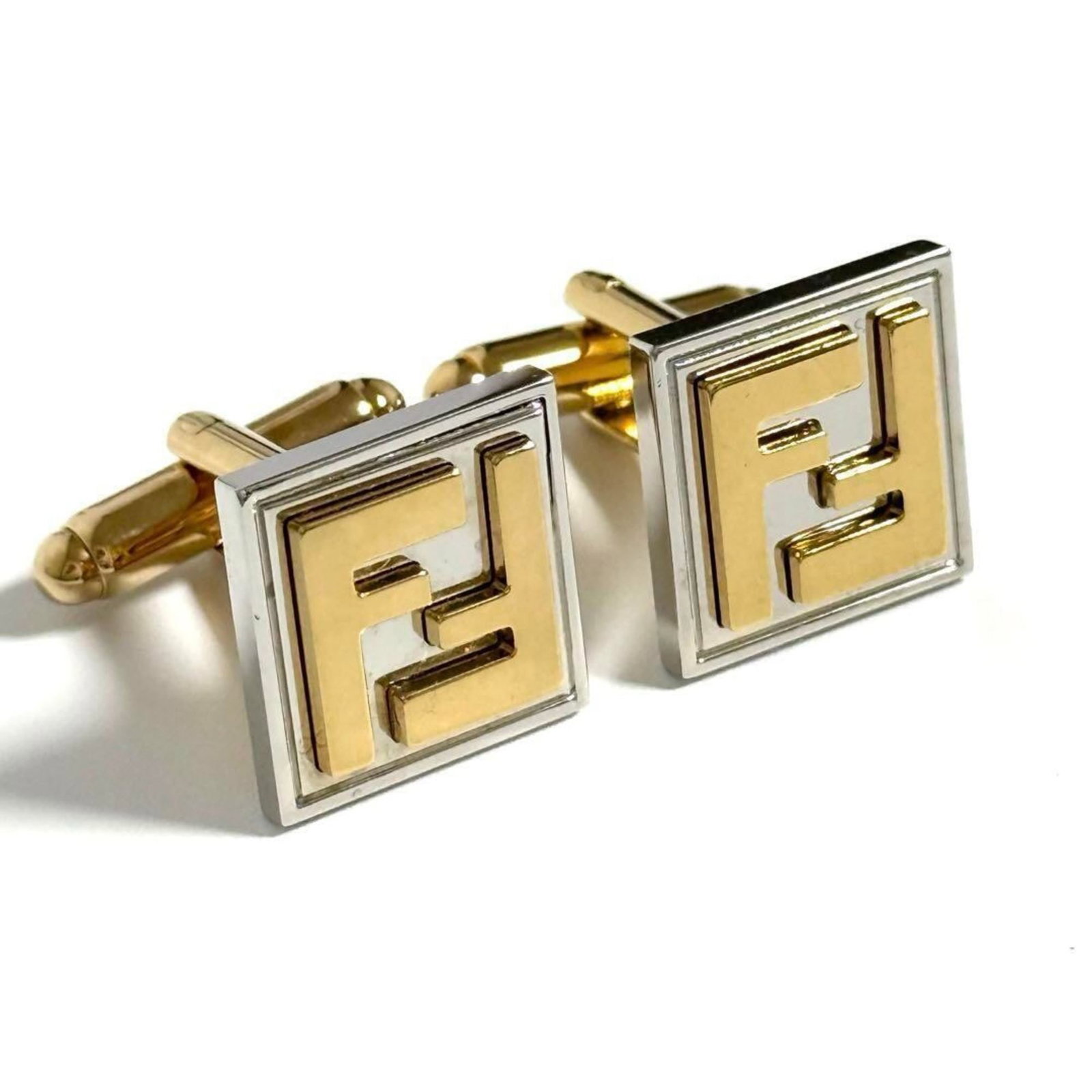 Metal Fendi Cufflinks: Metal Fendi Cufflinks Metal Fendi Cufflinks are crafted from metal, featuring a distinctive design. Bearing a signature, these cufflinks showcase the brand's iconic style. Measuring 15.00mm x
