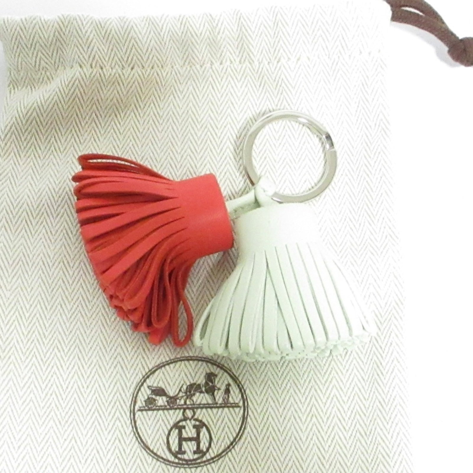 Hermes Handbag Charm: Hermes Handbag Charm Light Green and Red Hermes Handbag Charm. This used charm features a unique light green and red color combination, measuring 40mm x 50mm in size, with traces of usage visible due
