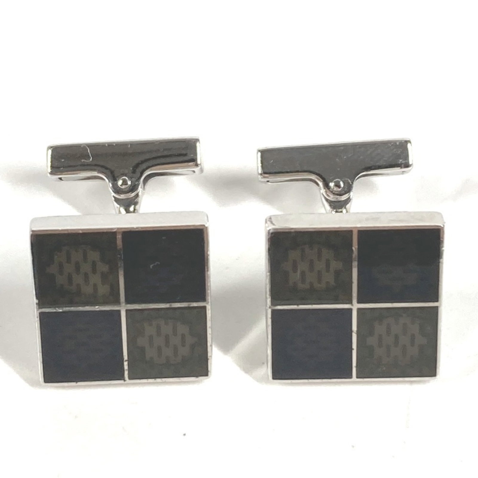 Louis Vuitton cufflinks silver 925: Louis Vuitton cufflinks silver 925 Silver 925 Louis Vuitton cufflinks with Damier Canvas design, bearing the iconic brand's signature style. The item shows signs of usage, including scratches and dirt