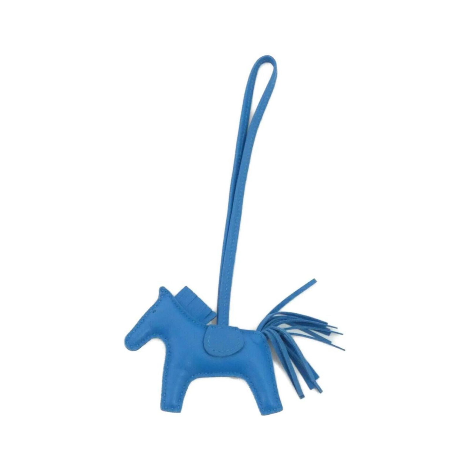 Hermes Handbag Charm Agneau Milo: Hermes Handbag Charm Agneau Milo Agneau Milo, the iconic Hermes handbag charm, boasts a striking blue hue and measures 75.00mm x 85.00mm in size. This versatile charm can be attached to various bags,