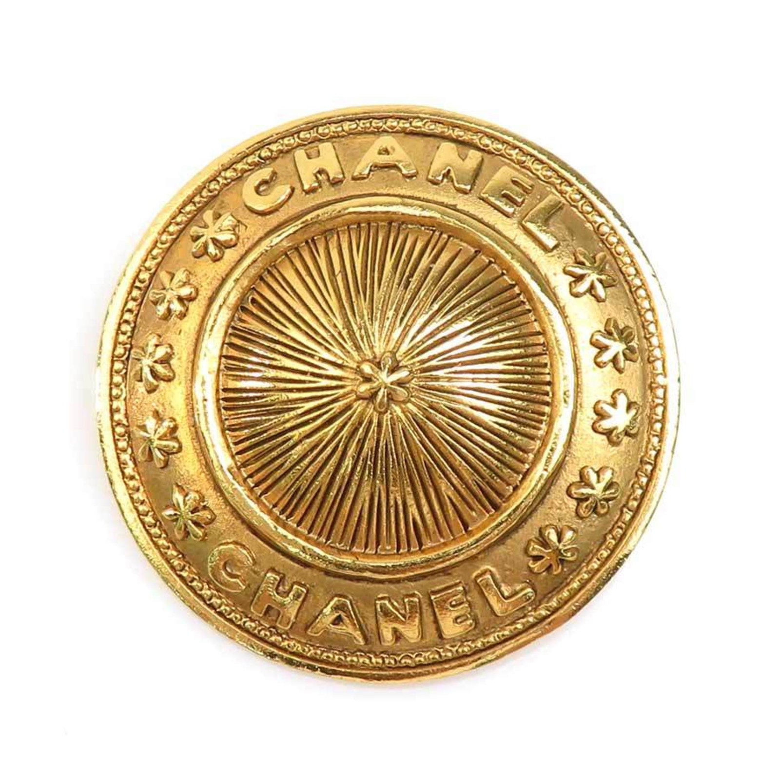 Metal brooch by Chanel: Metal brooch by Chanel Gold metal brooch by Chanel, measuring 3.8cm x 3.8cm, bears visible traces of usage and minor scratches/dirt. The item's condition reflects its used state, with signs of wear ev