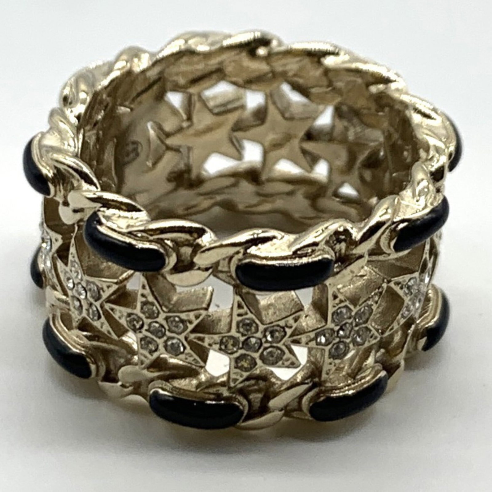 Metal Ring Chanel Band: Metal Ring Chanel Band Metal Ring Chanel Band features a metal band ring with rhinestone accents, showcasing a classic design. The item has been used and shows signs of wear, but remains in