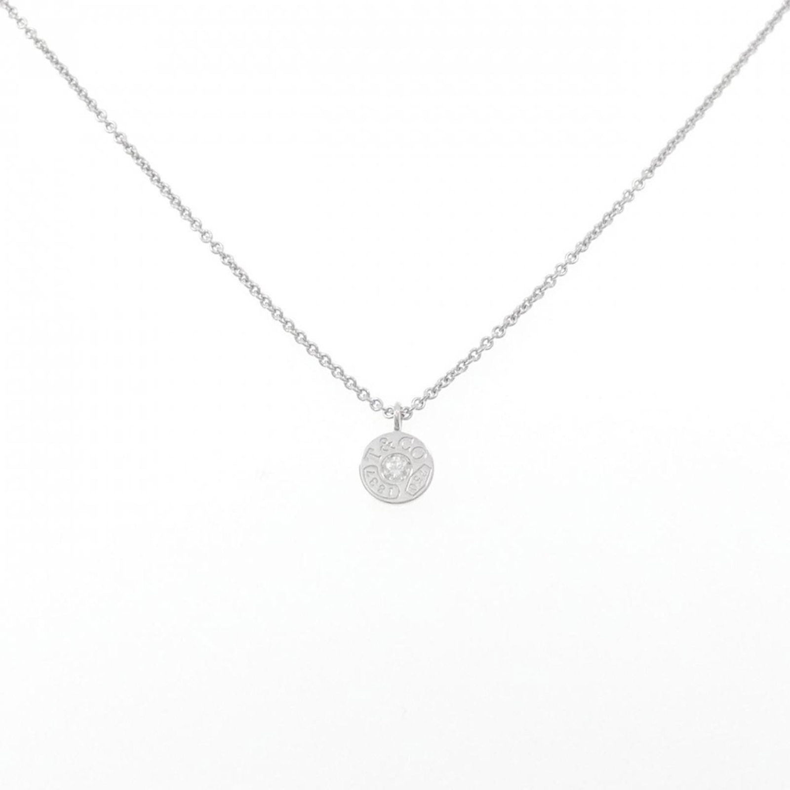 Circle necklace Tiffany 1837: Circle necklace Tiffany 1837 White gold necklace from Tiffany & Co. features a 8mm pendant with a circle design, suspended from a chain with a 41 cm neck circumference. This piece is made from 18K