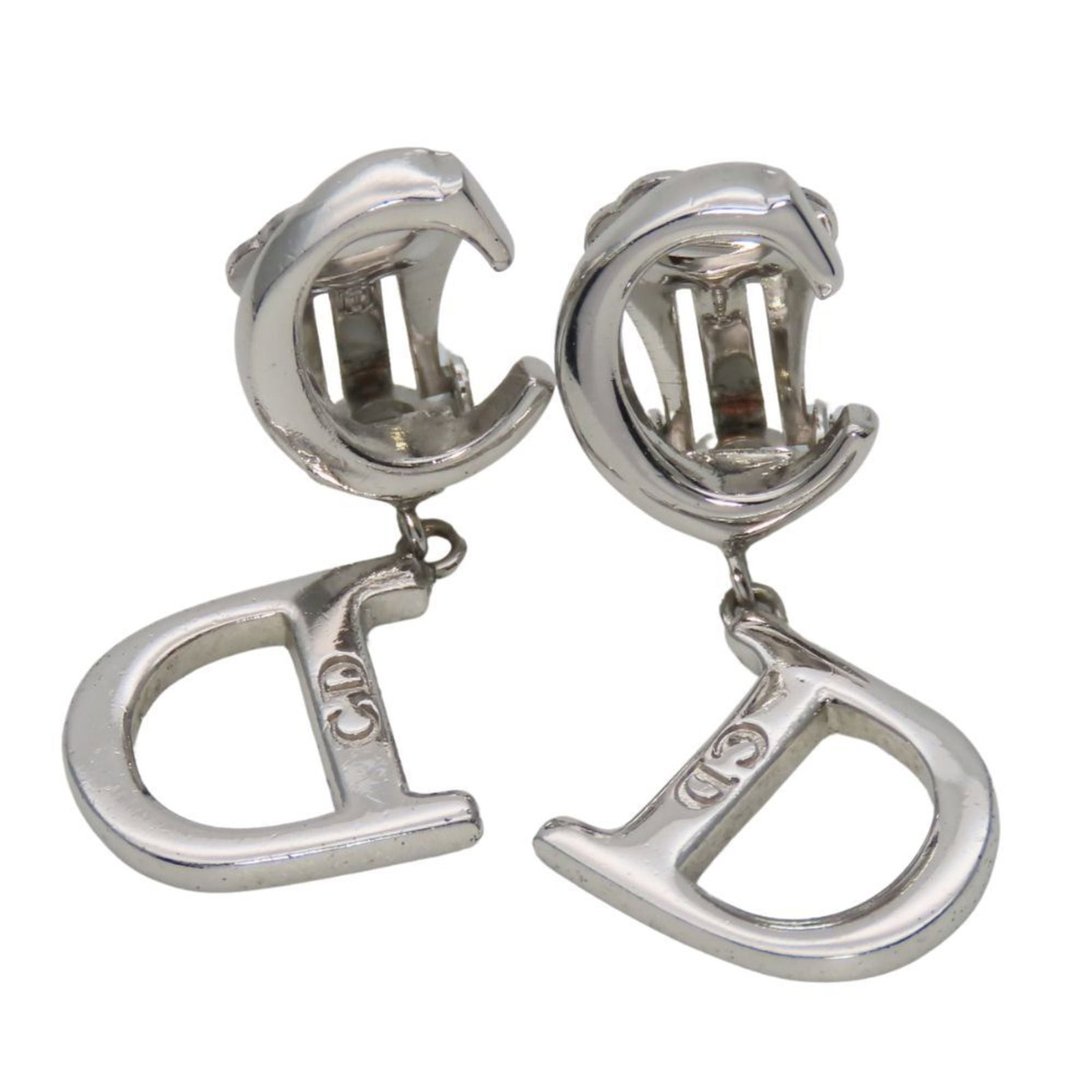 Metal clip earrings by Christian Dior: Metal clip earrings by Christian Dior Silver metal clip earrings from Christian Dior, bearing a few traces of usage and minor scratches. Made with durable metal, these earrings have a sleek design