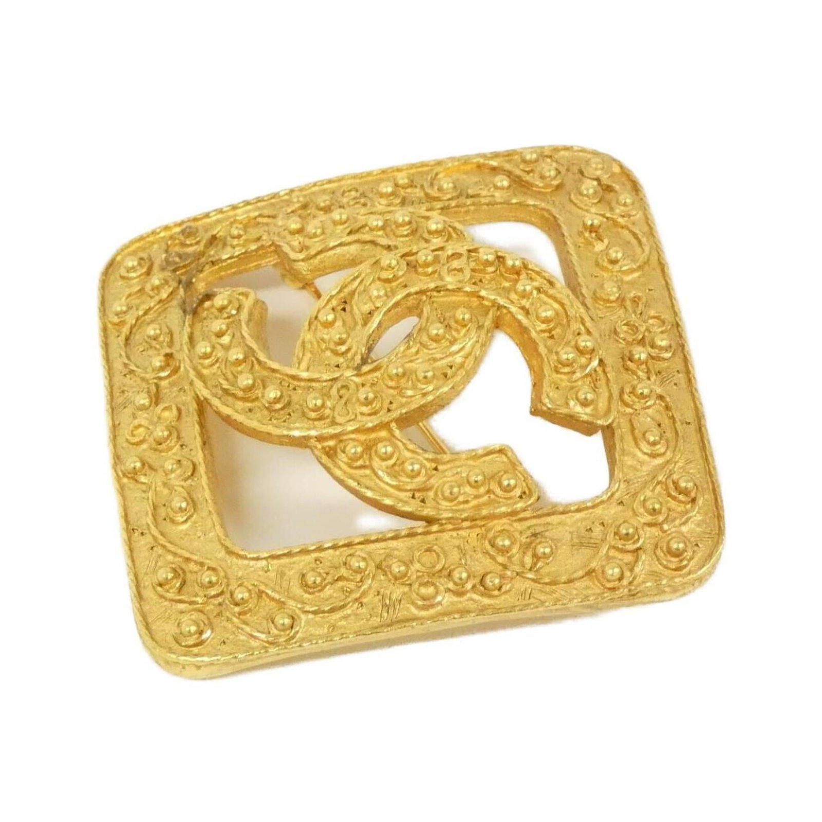 Chanel Brooch: Chanel Brooch Gold Chanel Brooch, measuring 6cm x 6cm, bears a few traces of usage with some scratches and dirt. The brooch is in very good condition overall, reflecting its age. A notable feature of 