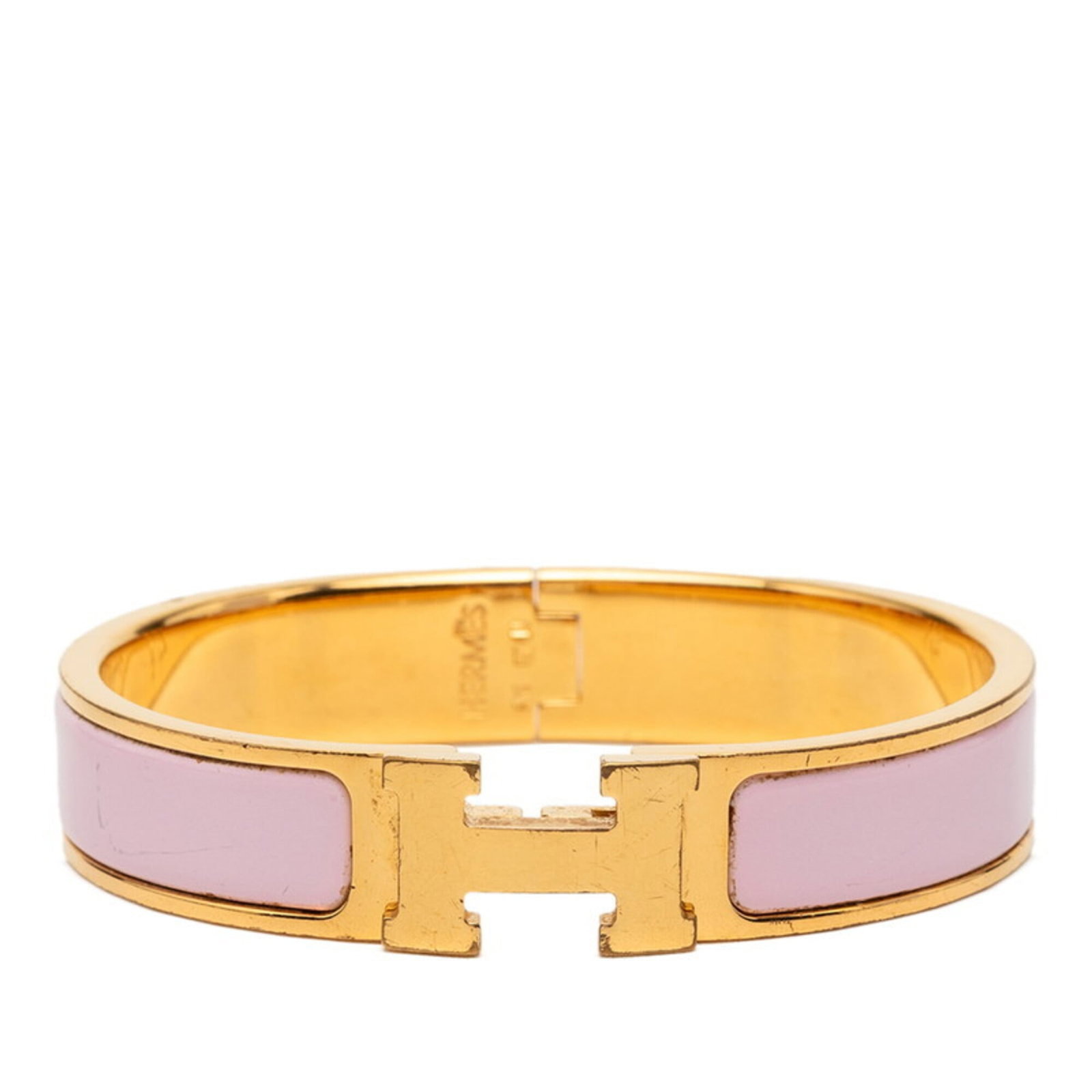 Charm Bracelet by Hermes: Charm Bracelet by Hermes Gold and pink charm bracelet by Hermes, measuring 15cm in length, features subtle traces of usage with minor scratches and dirt. The classic design showcases the iconic