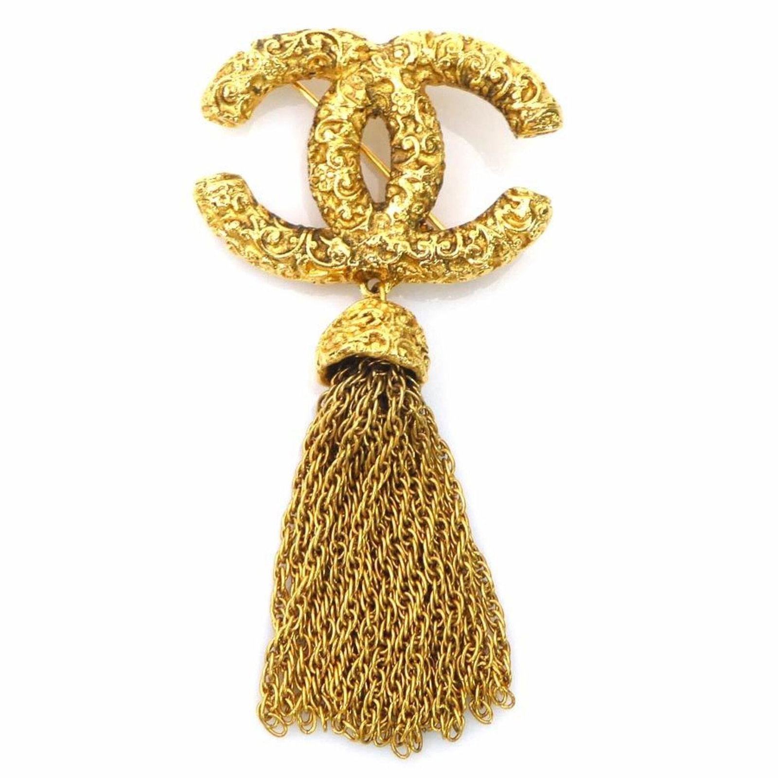 Metal brooch by Chanel: Metal brooch by Chanel Gold metal brooch by renowned fashion house Chanel, bearing traces of usage and minor scratches. The brooch's condition is generally good despite showing signs of wear. A piece